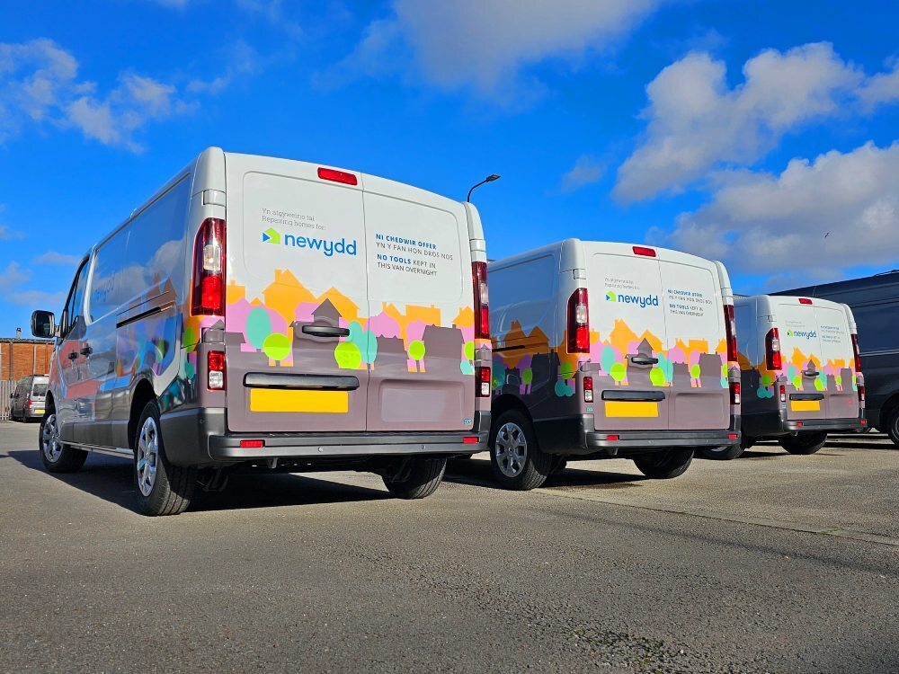 Matching vehicle graphics on rear end of fleet of company vans.