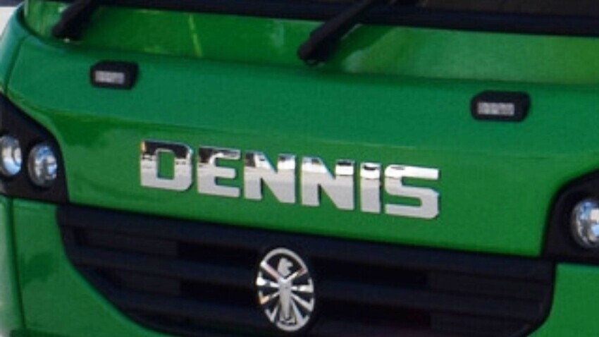 Dennis emblem on the front of a green truck.