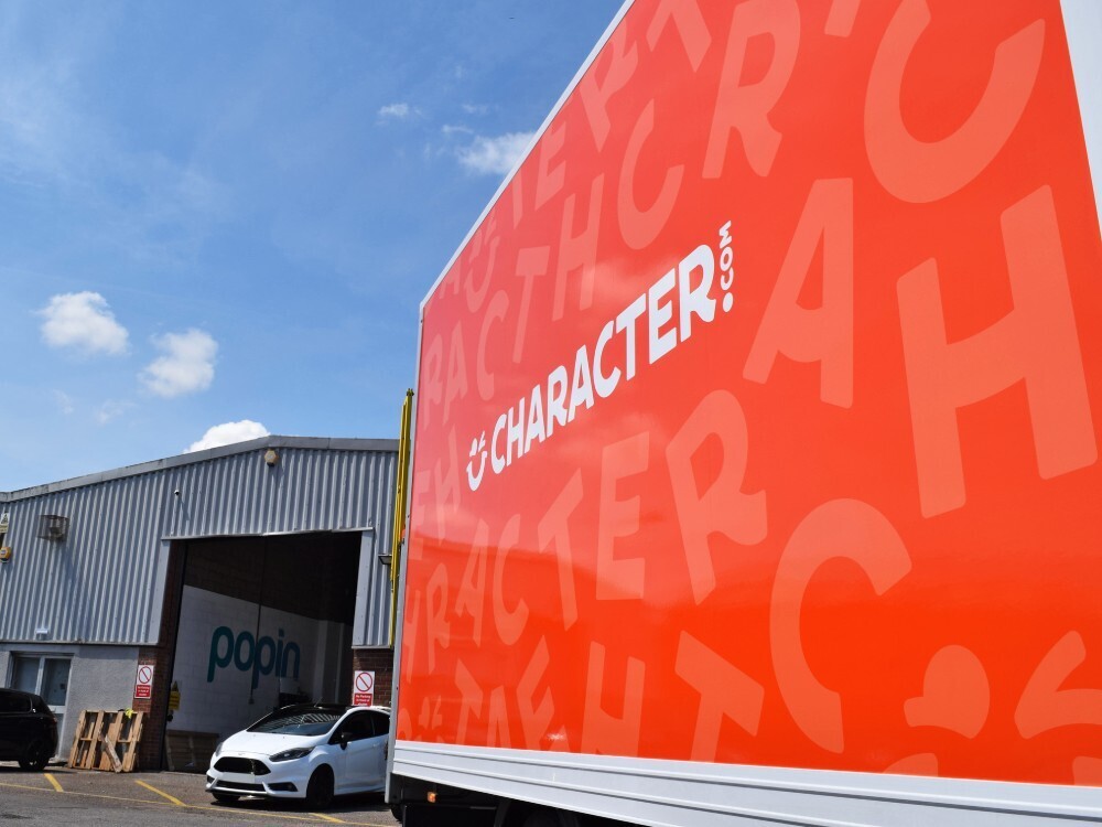 Bright orange Character.com vehicle livery on side of Iveco Daily Box van.