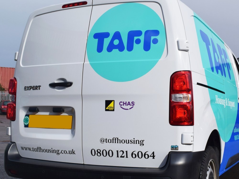 White Peugeot Expert van with rear vinyl graphics.