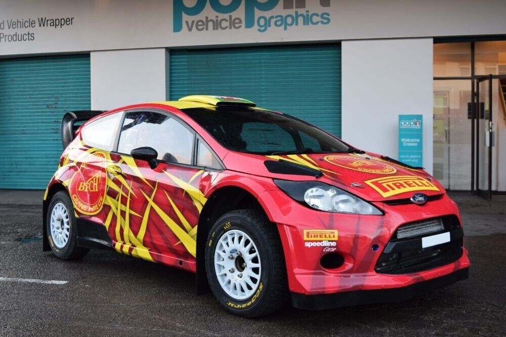 Ford Fiesta R5 company car with bold red and yellow commercial vehicle wrap outside Popin in Cardiff.