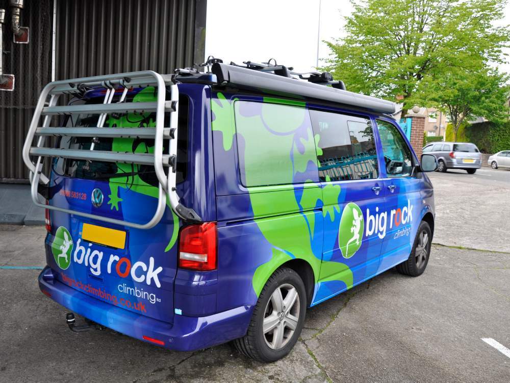 Colourful blue and green branded van wrap on company Volkswagen California.