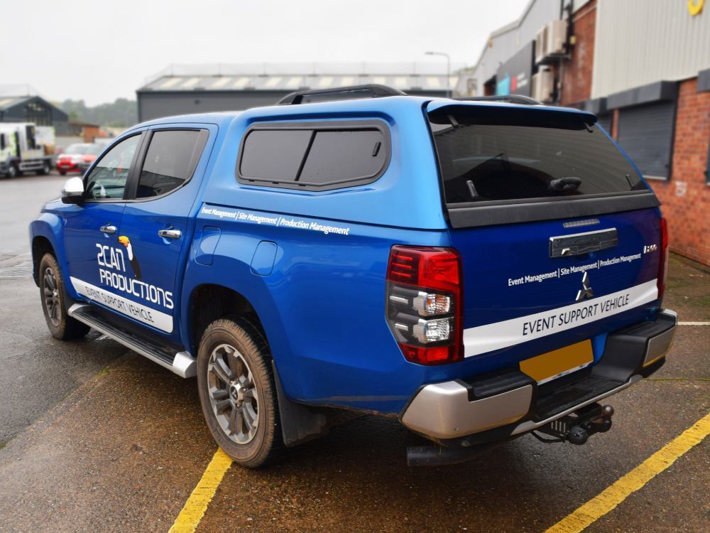 Branded company vehicle graphics on blue Mitsubishi L200.