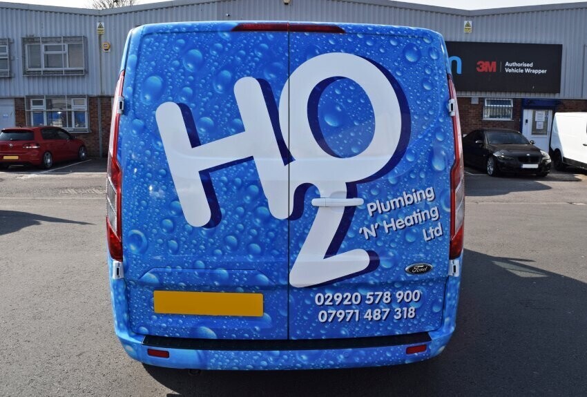 Bold branded vehicle wrap on the rear of a company van for a local plumbing business.