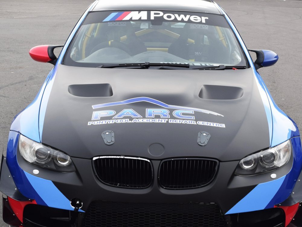 Black car wrap and branded vinyl graphics on a company BMW M3.