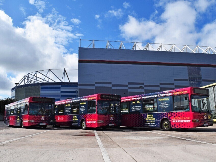 Cardiff Bus fleet with new matching vehicle wraps outside football stadium.