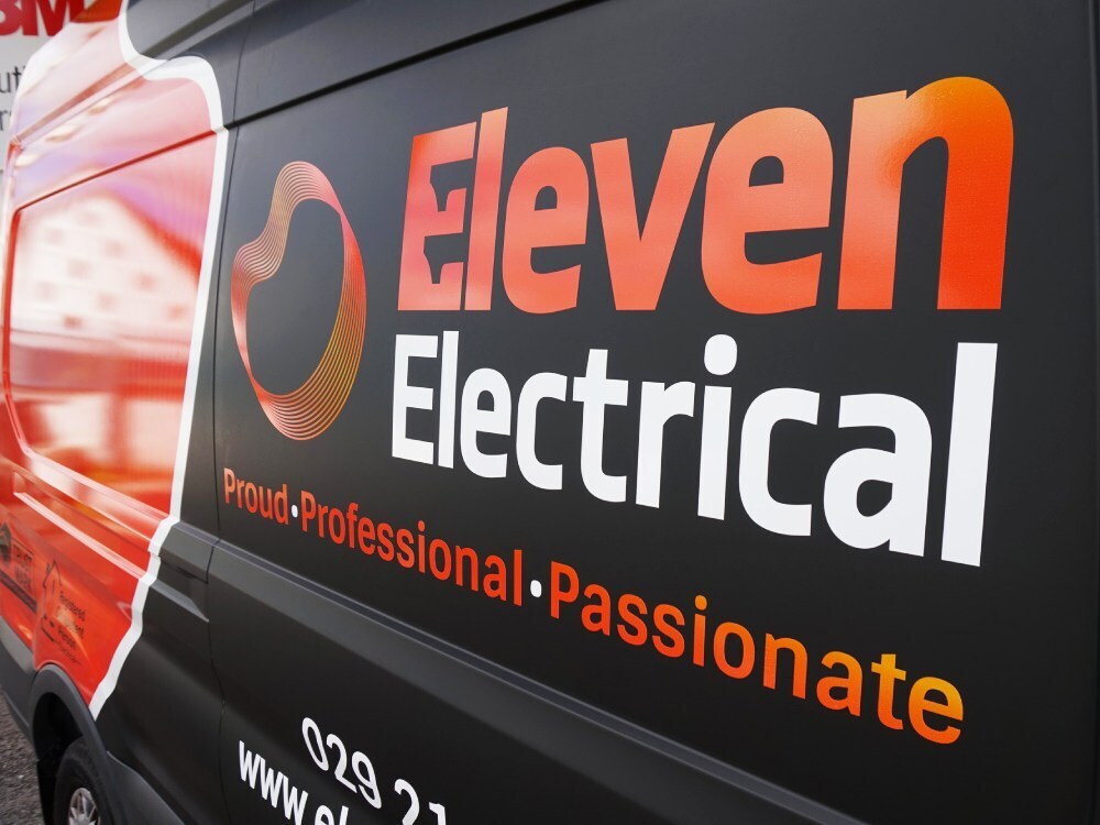 Vehicle graphics on a matte black company Ford Transit van.