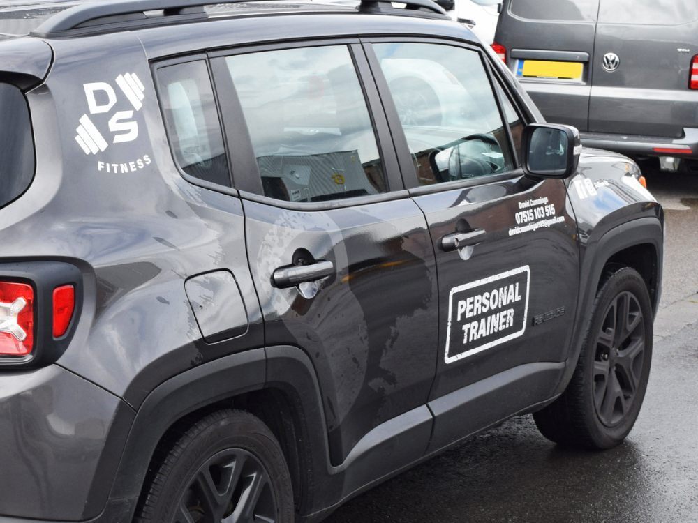 Grey Jeep with white company branded vinyl graphics.