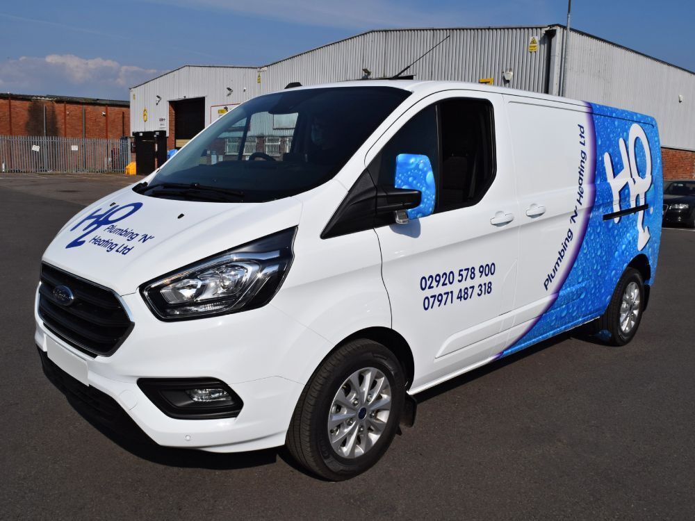 Company branded partial vehicle wrap on white Ford Transit Custom van.