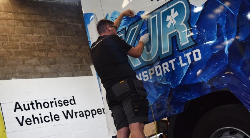 Installing a vinyl wrap onto a DAF lorry.
