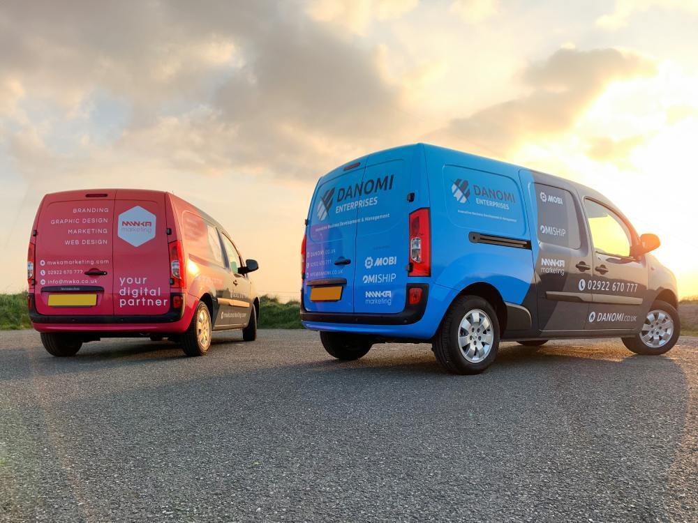 Two Mercedes Citan company vans with branded vehicle wraps at sunset.