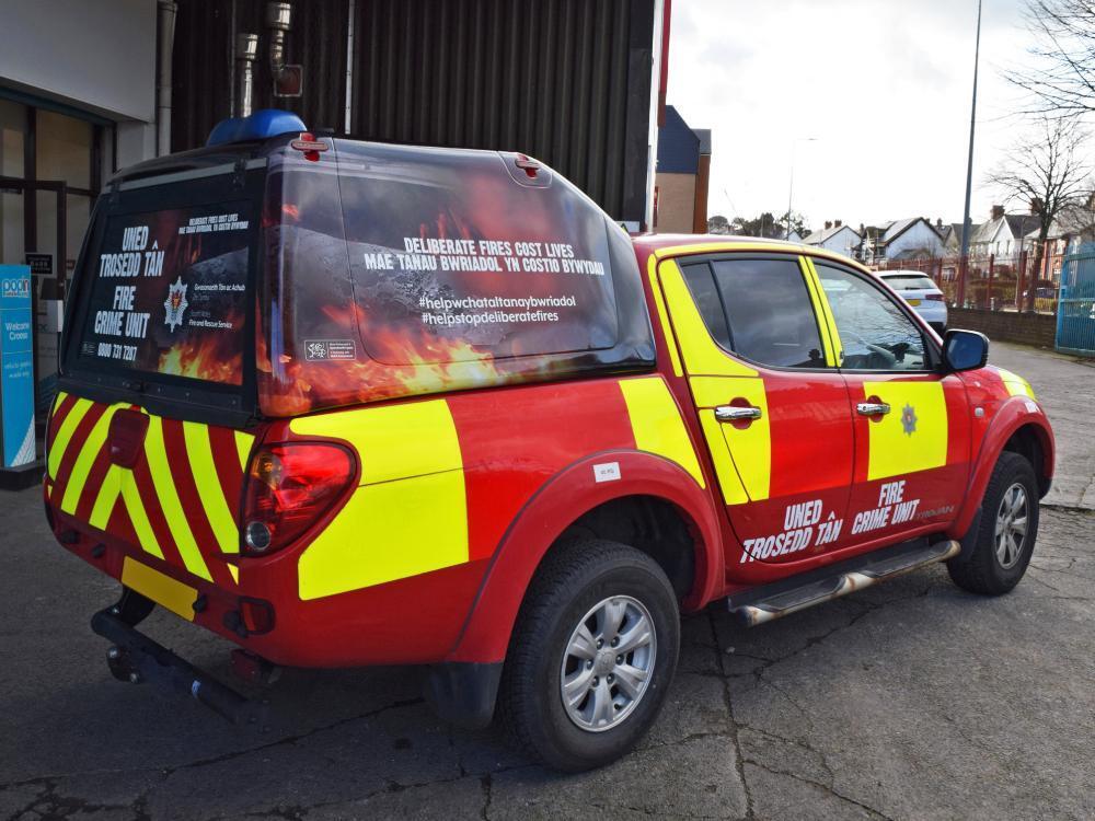 Red and reflective yellow South Wales Fire vehicle livery on Mitsubishi L200.