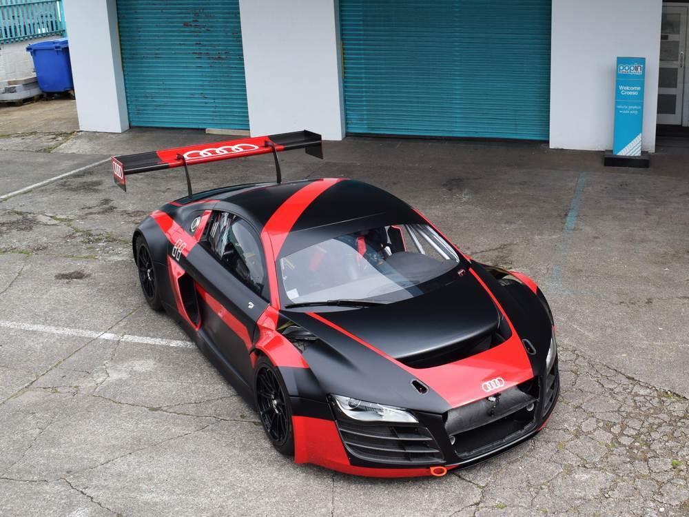 Company Audi R8 LMS with black and red livery and graphics outside Popin in Cardiff.