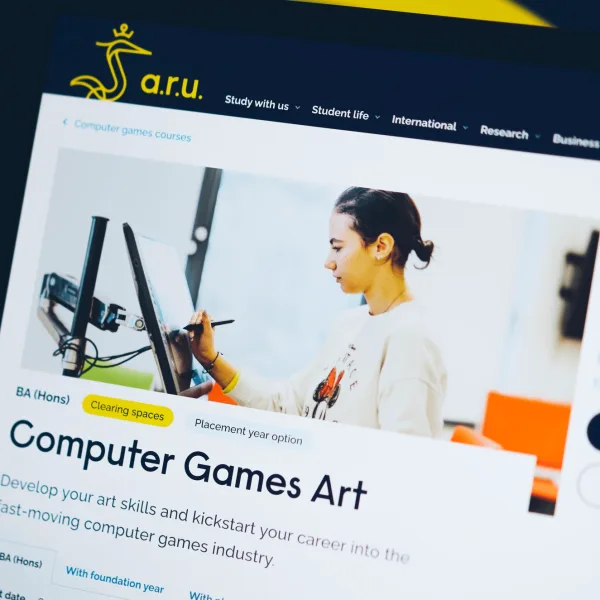 A shallow focus photo of the ARU course page design on a computer screen. Only the top part of the page is shown. The image is shot from a quirky angle and abstract brand elements can be seen in the background.