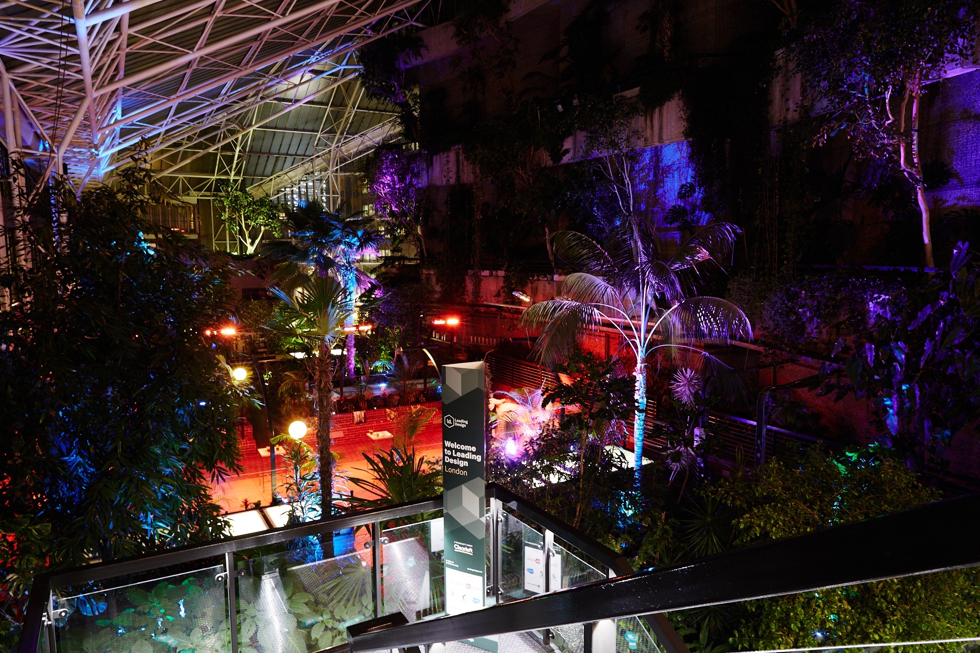 Inside the garden of the Barbican at night, lit dramatically.