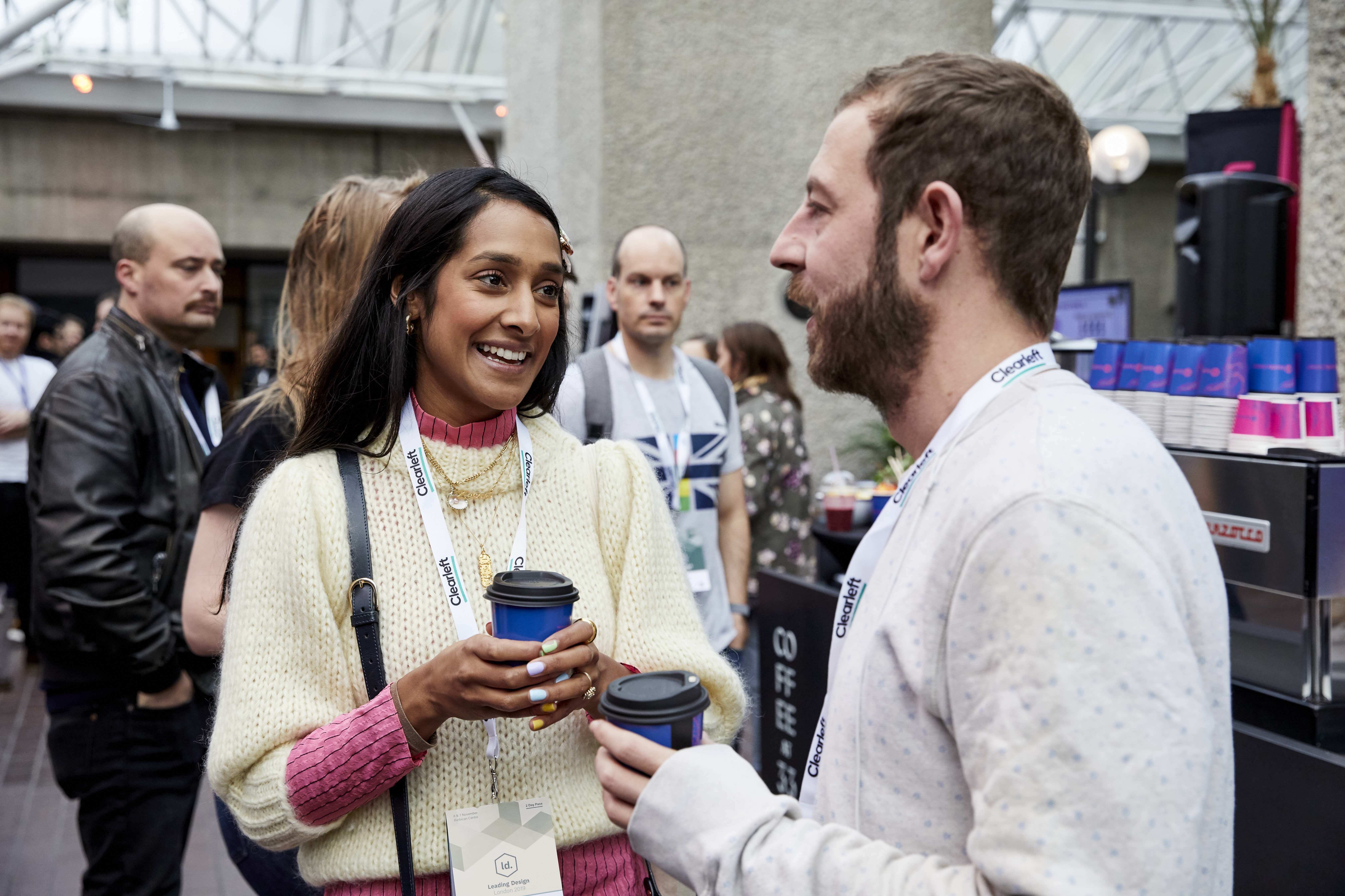 A man and a woman smiling and chatting during a coffee break.