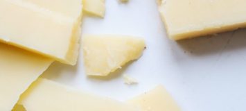 Cheddar cheese with a bite taken out of it.