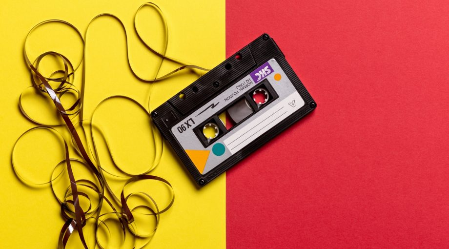 Black cassette tape on top of red and yellow surface 1626481