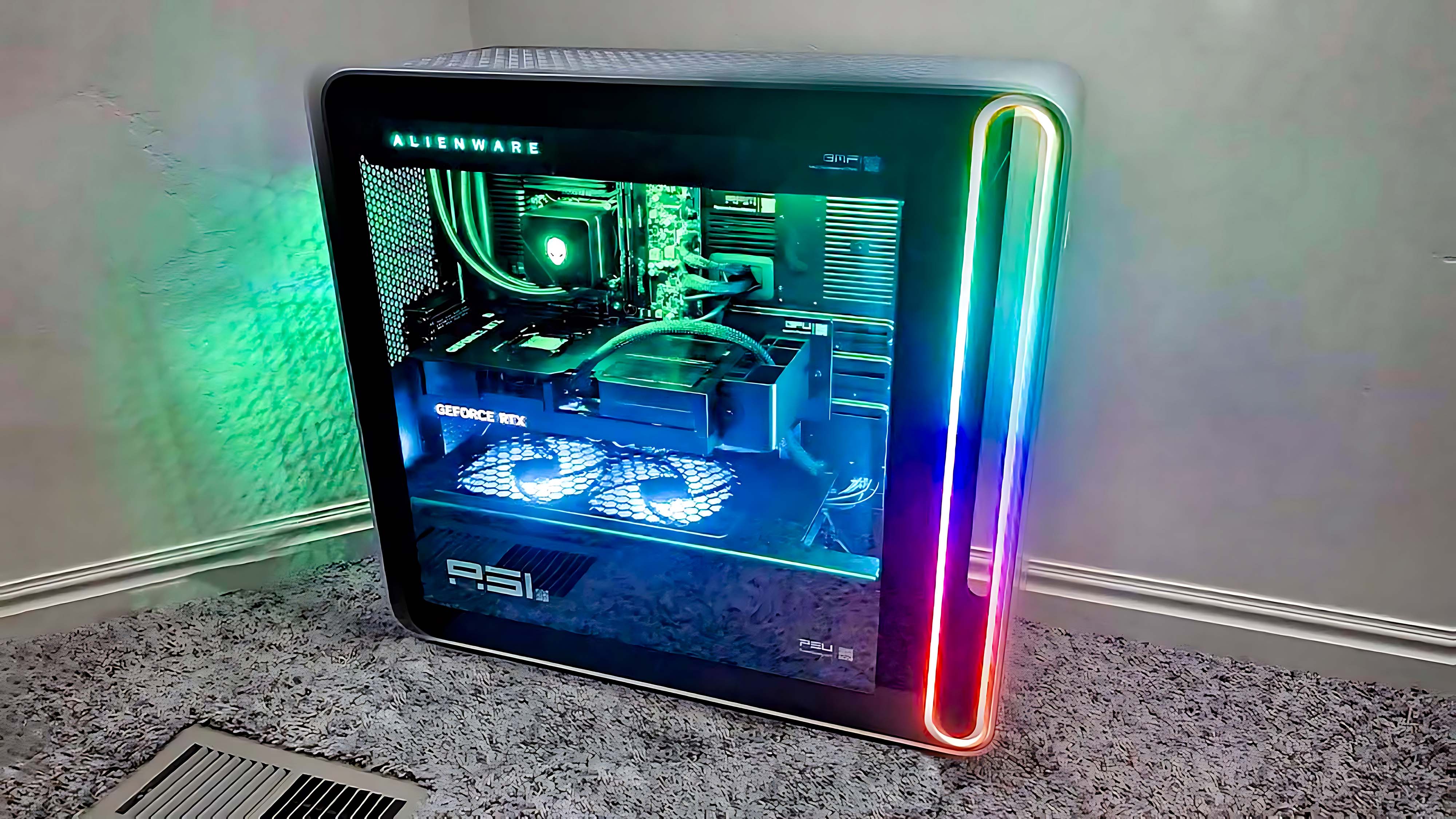 Игровой компьютер Alienware Area-51 (2025) на полу и освещенный красочным RGB-освещением.