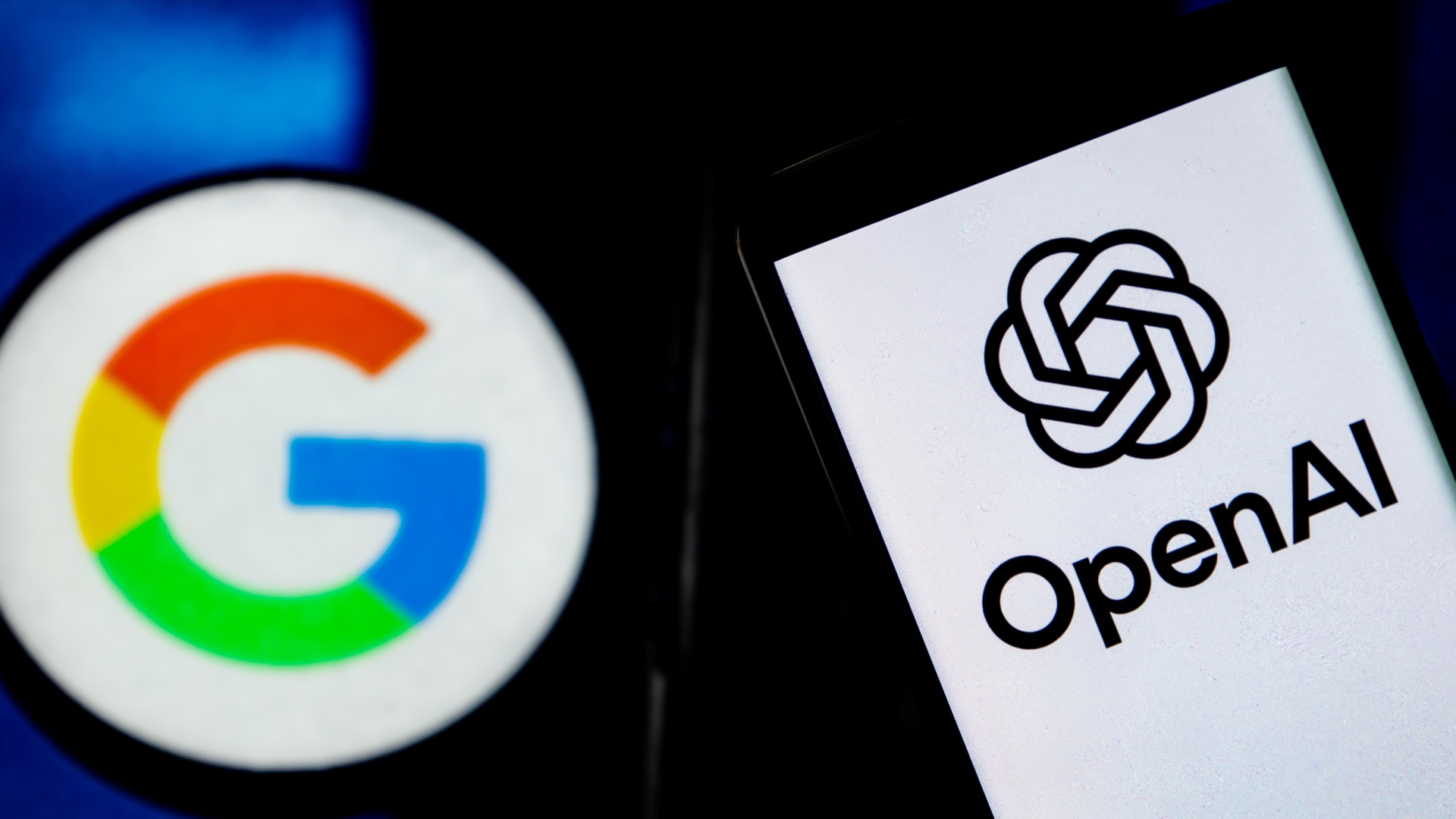 Логотип OpenAI отображается на экране смартфона с логотипом Google на заднем плане.