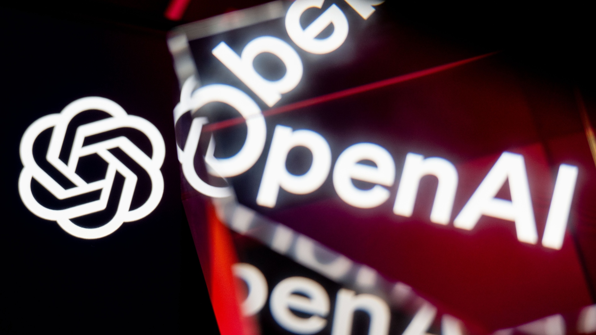 Логотипы OpenAI отображаются и отражаются на экранах.