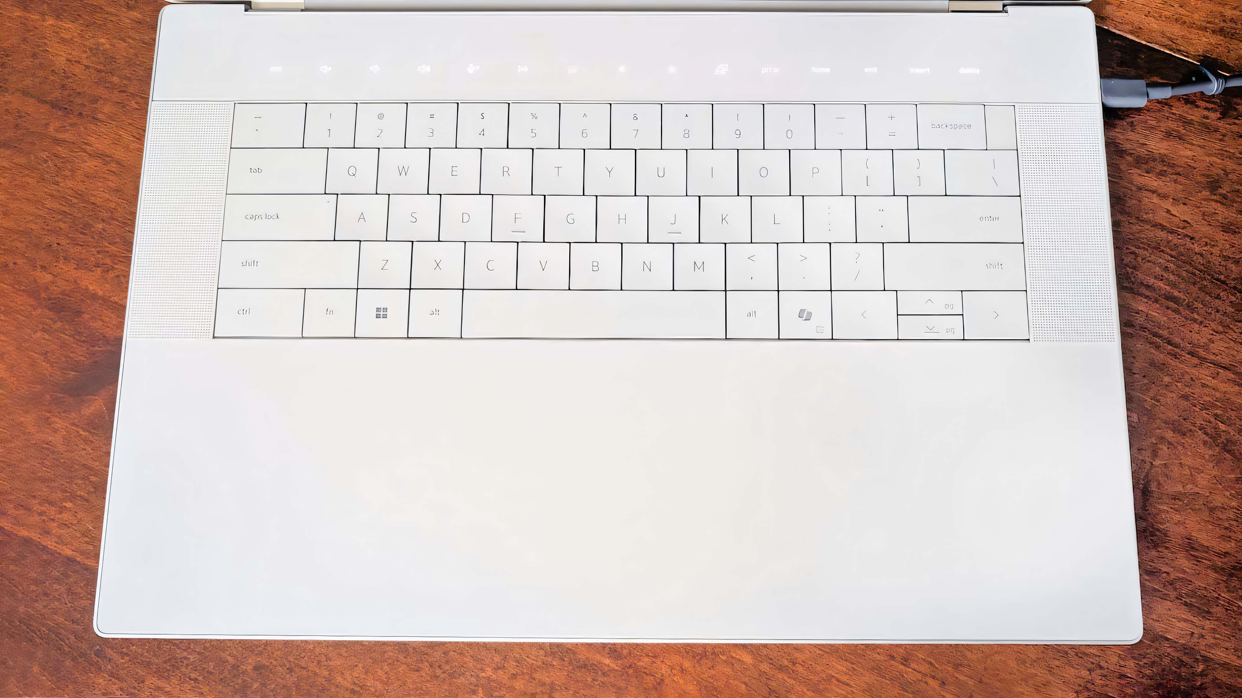 Снимок, в котором основное внимание уделяется клавиатуре Dell 16 Premium и невидимой сенсорной панели.