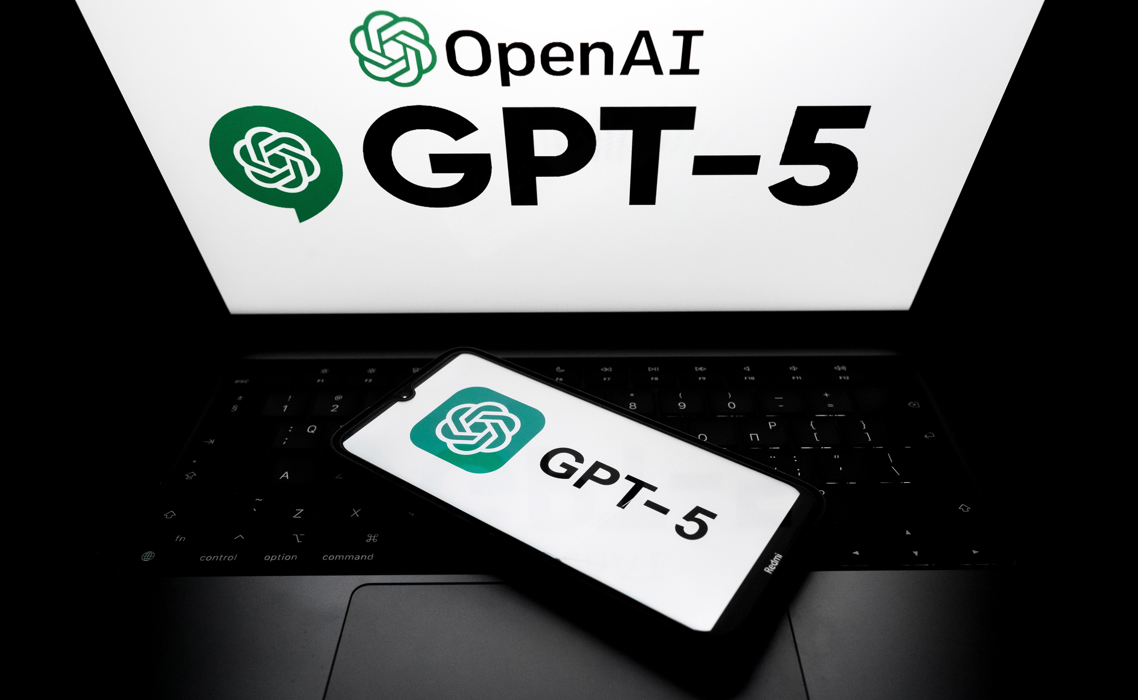 Логотип OpenAI GPT-5 на экране смартфона и на фоне экрана ноутбука на этой фотографии, сделанной в Афинах, Греция, 7 августа 2025 года. (Фотография Nikolas Kokovlis/NurPhoto через Getty Images)