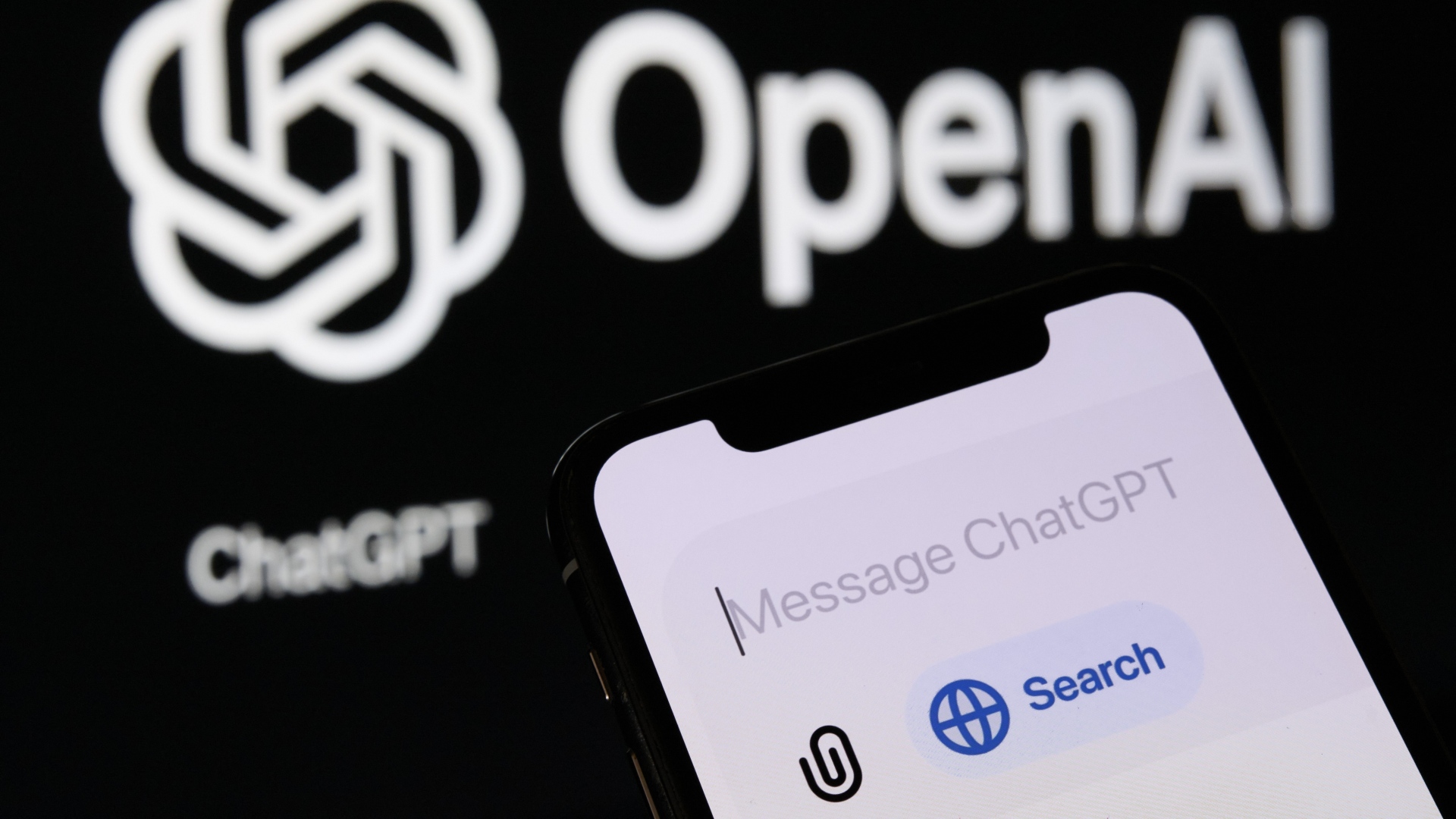 Телефон с новой функцией ChatGPT "Поиск" и логотип OpenAI на фоне