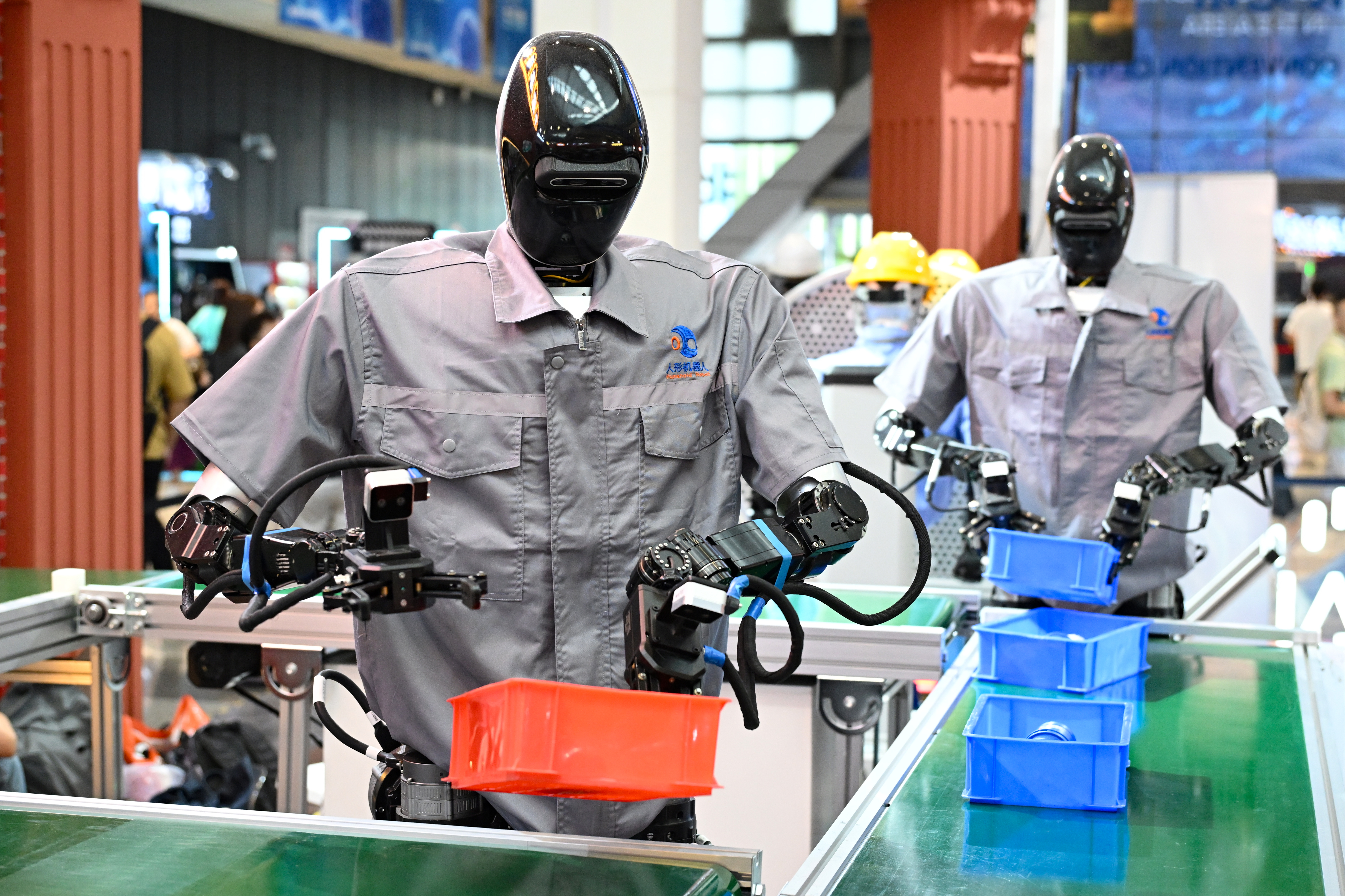 SHANGHAI, CHINA - JULY 26: Humanoid robots Qinglong sort goods at the logistics sorting line during the exhibition of 2025 World Artificial Intelligence Conference (WAIC2025) at the Shanghai World Expo Exhibition and Convention Center on July 26, 2025 in Shanghai, China. Under the theme ![