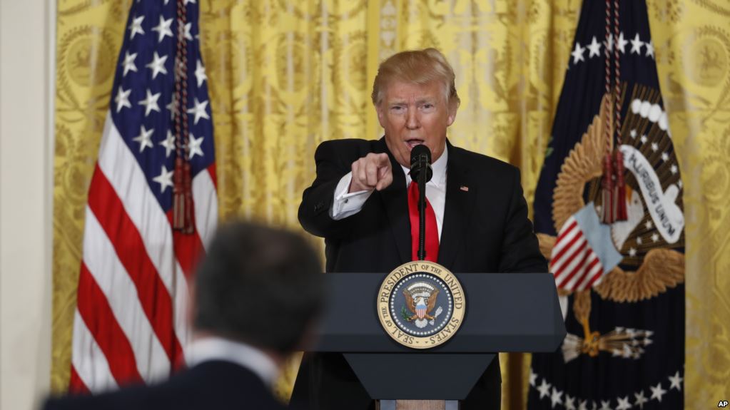 Президент США Трамп стоит за трибуной.