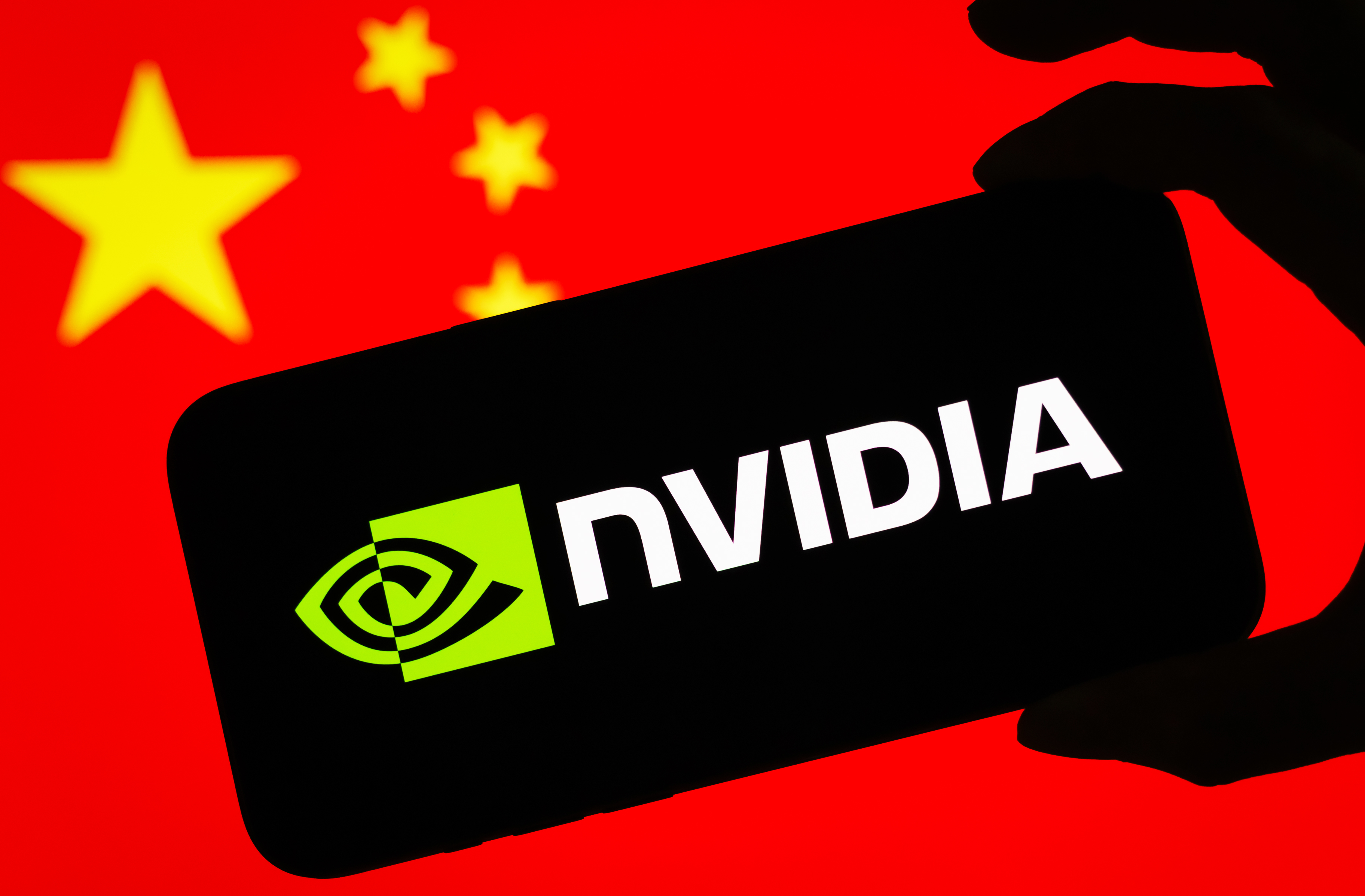 Логотип NVIDIA отображается на телефоне на фоне национального флага Китая.