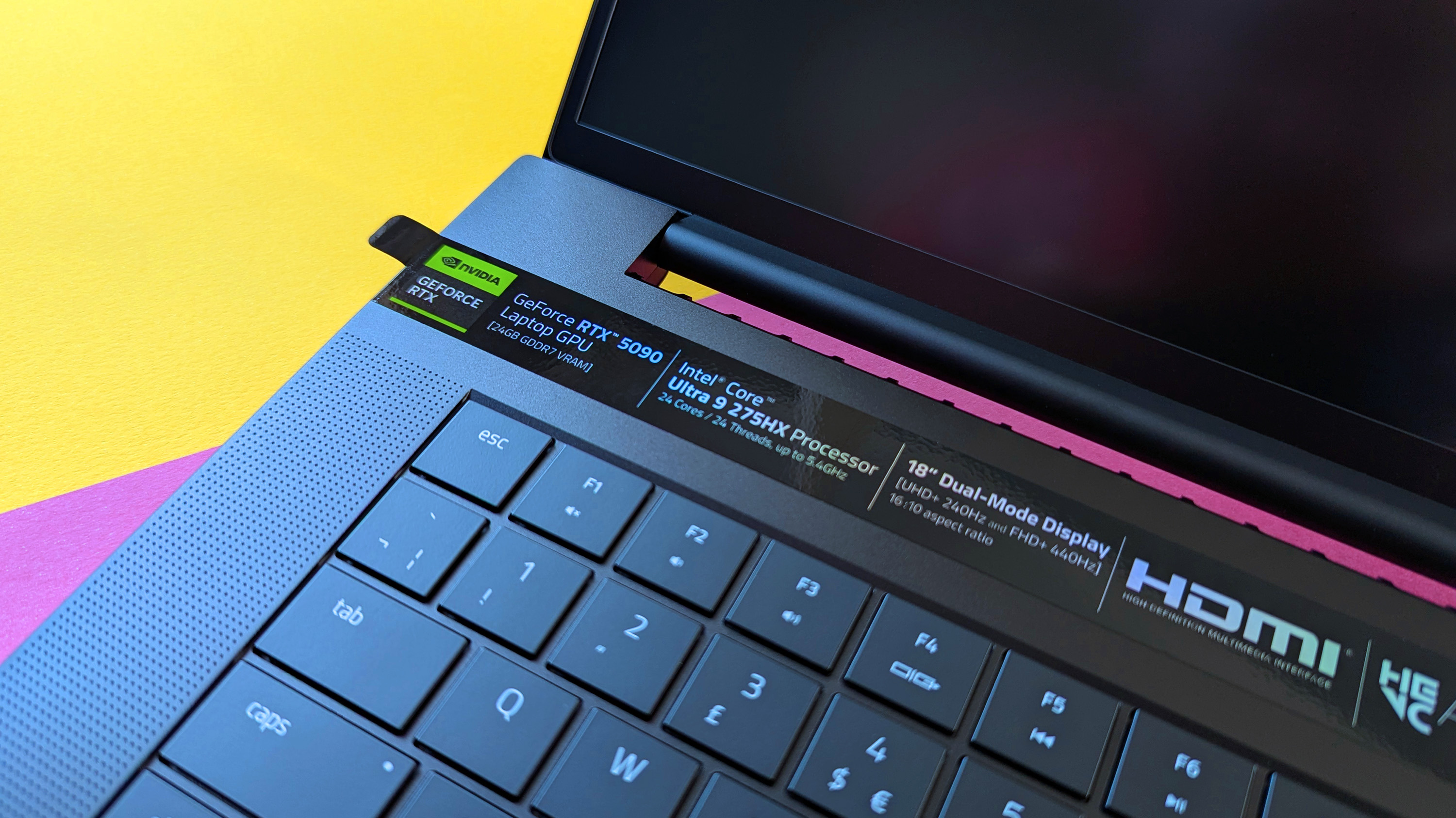 Razer Blade 18 (2025) игровой ноутбук на розовом и желтом фоне.
