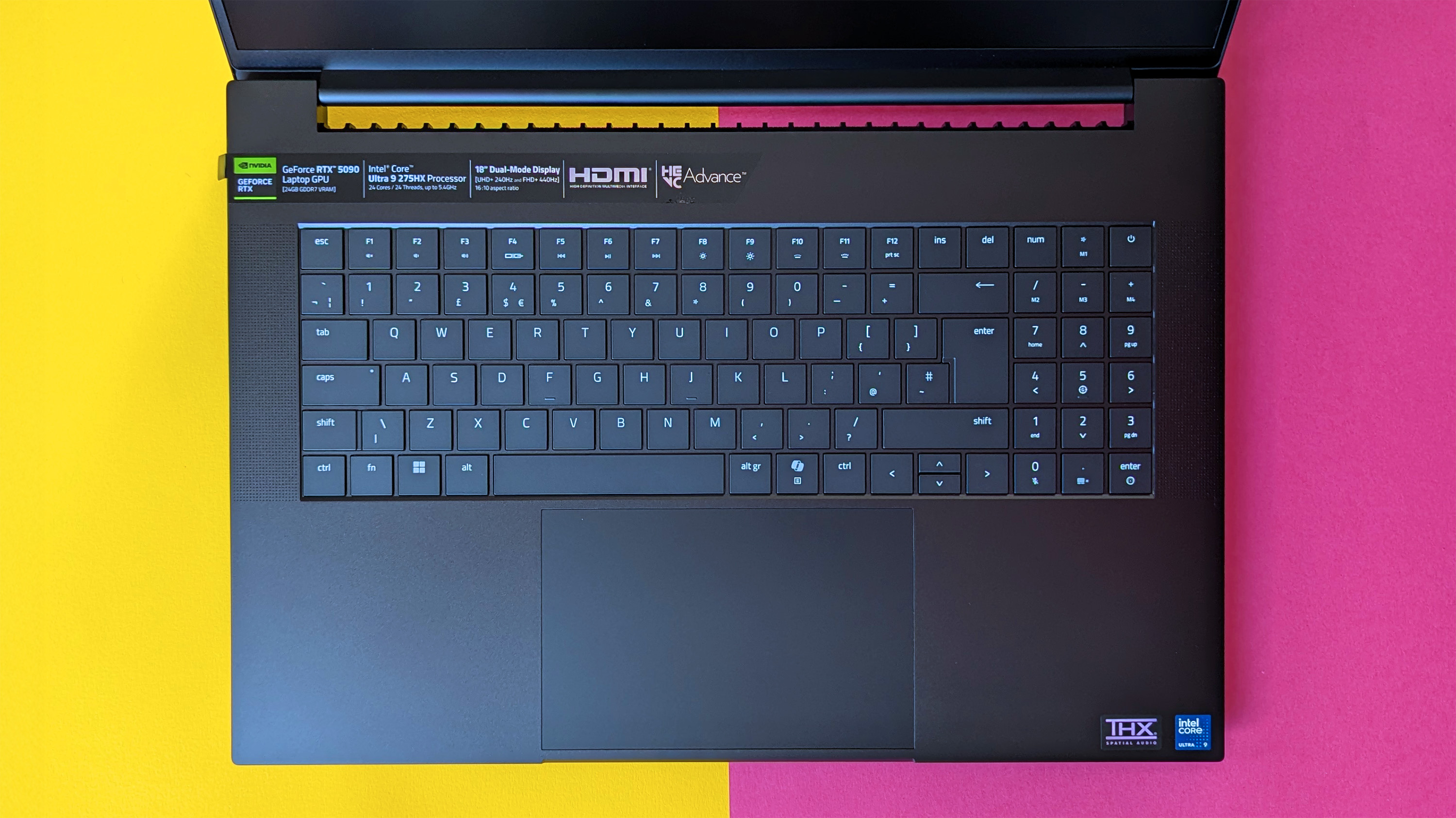 Razer Blade 18 (2025) игровой ноутбук на розовом и желтом фоне.