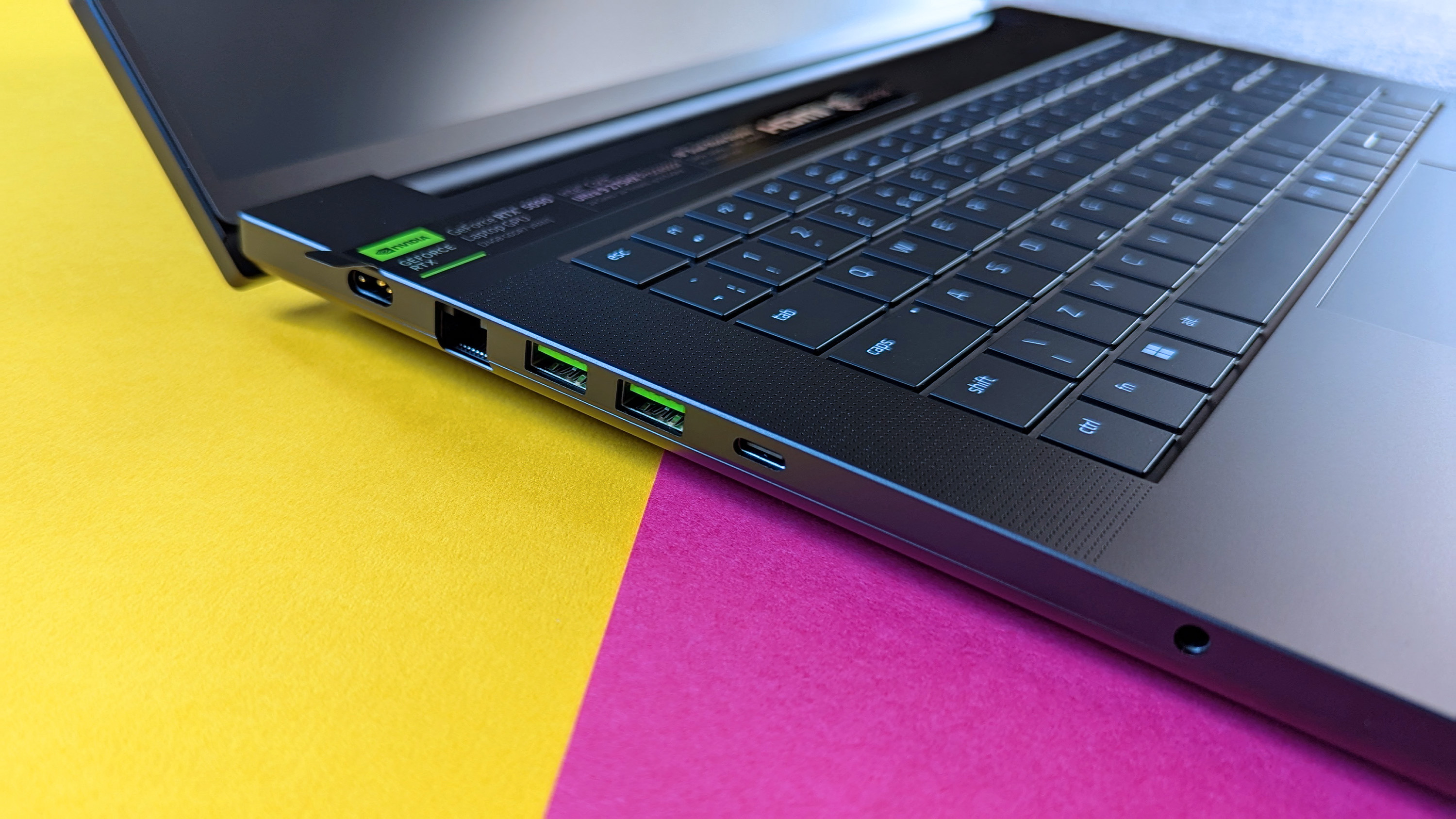 Razer Blade 18 (2025) игровой ноутбук на розовом и желтом фоне.