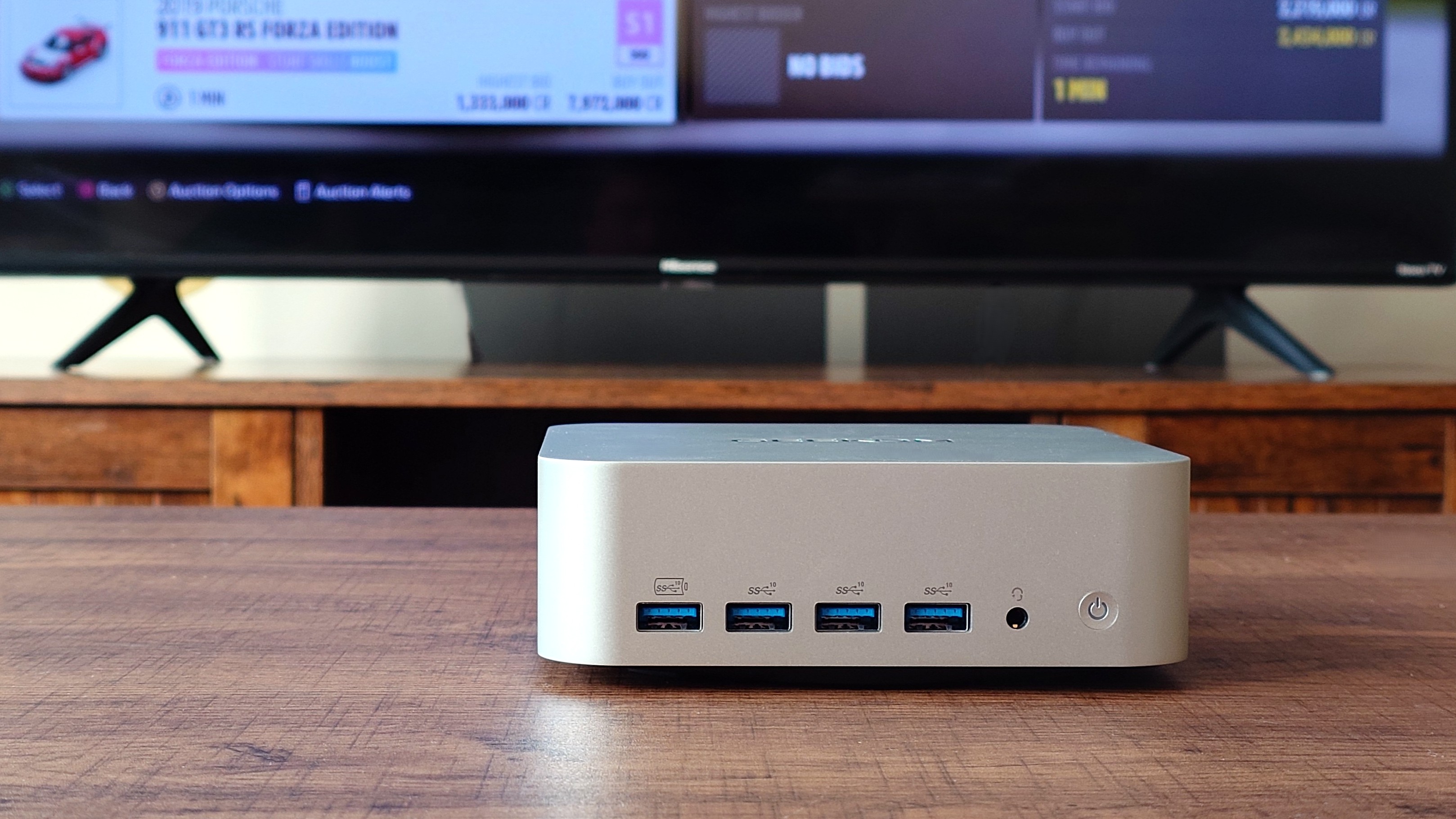Geekom A9 Max вид спереди, показывающий четыре порта USB 3.2, кнопку питания и разъем для наушников.