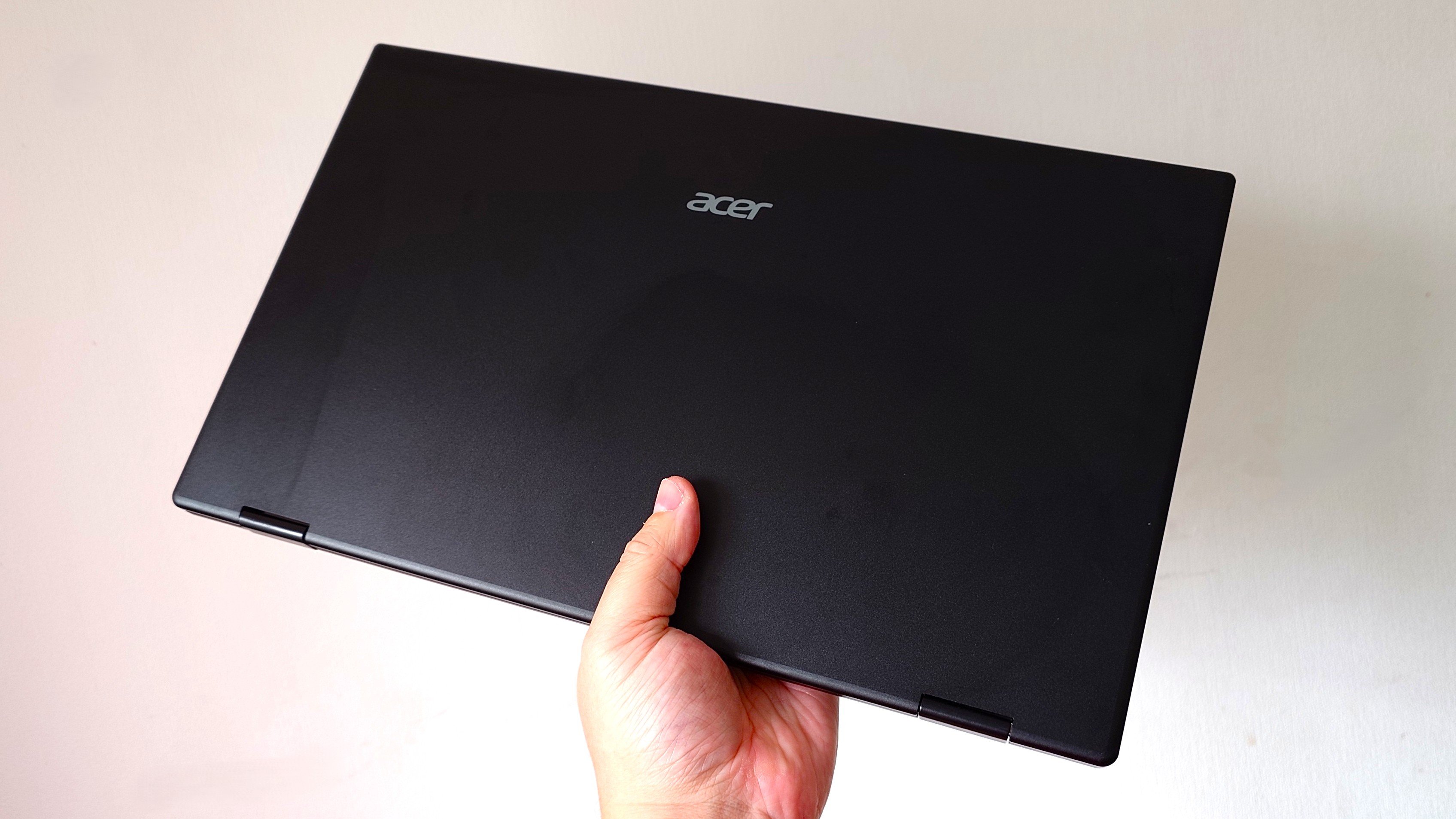 Acer's dual-screen portable monitor closed and held in the hand.