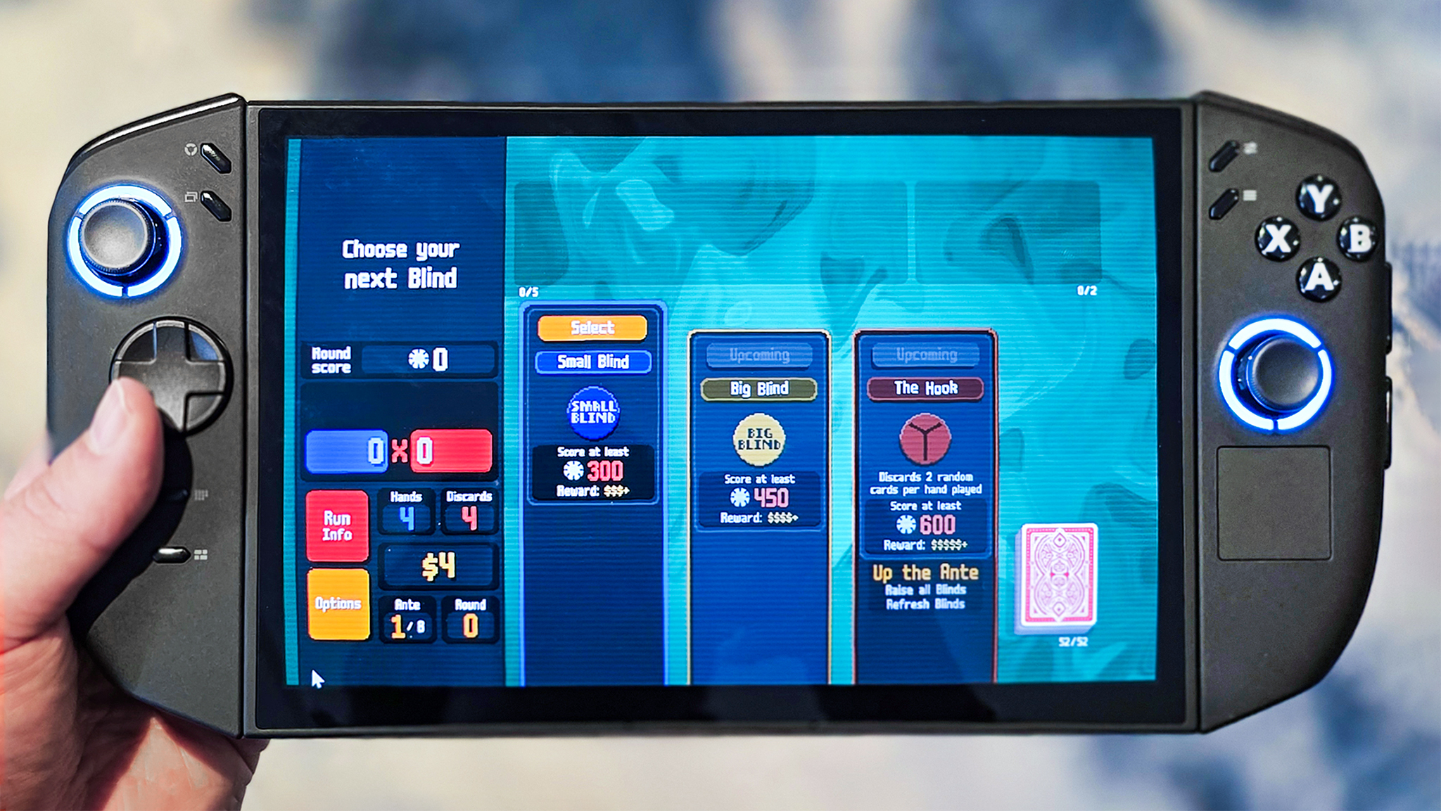 Lenovo Legion Go 2 в руке человека с запущенной игрой Balatro.
