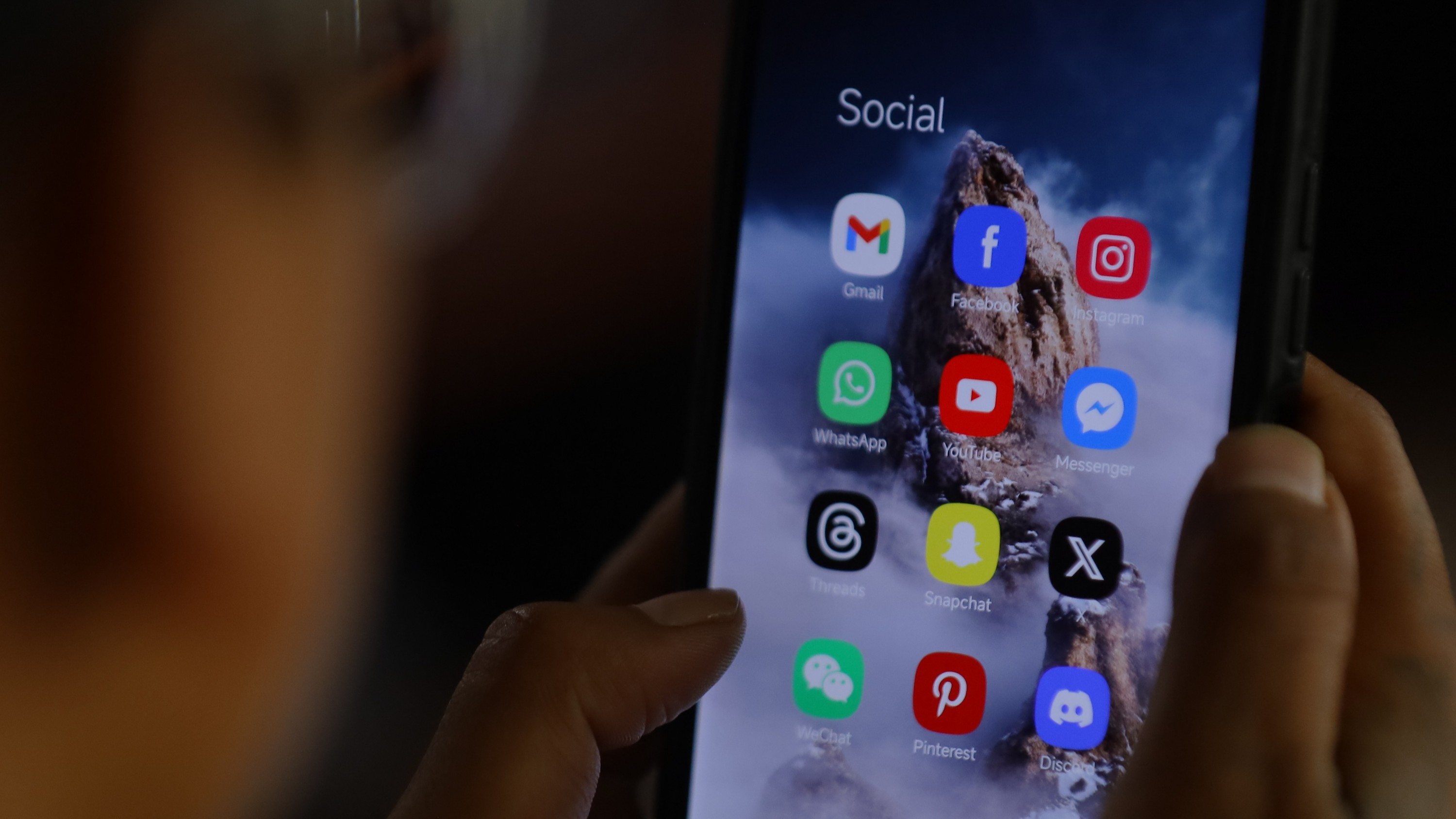 Social media apps appear on the screen of a phone