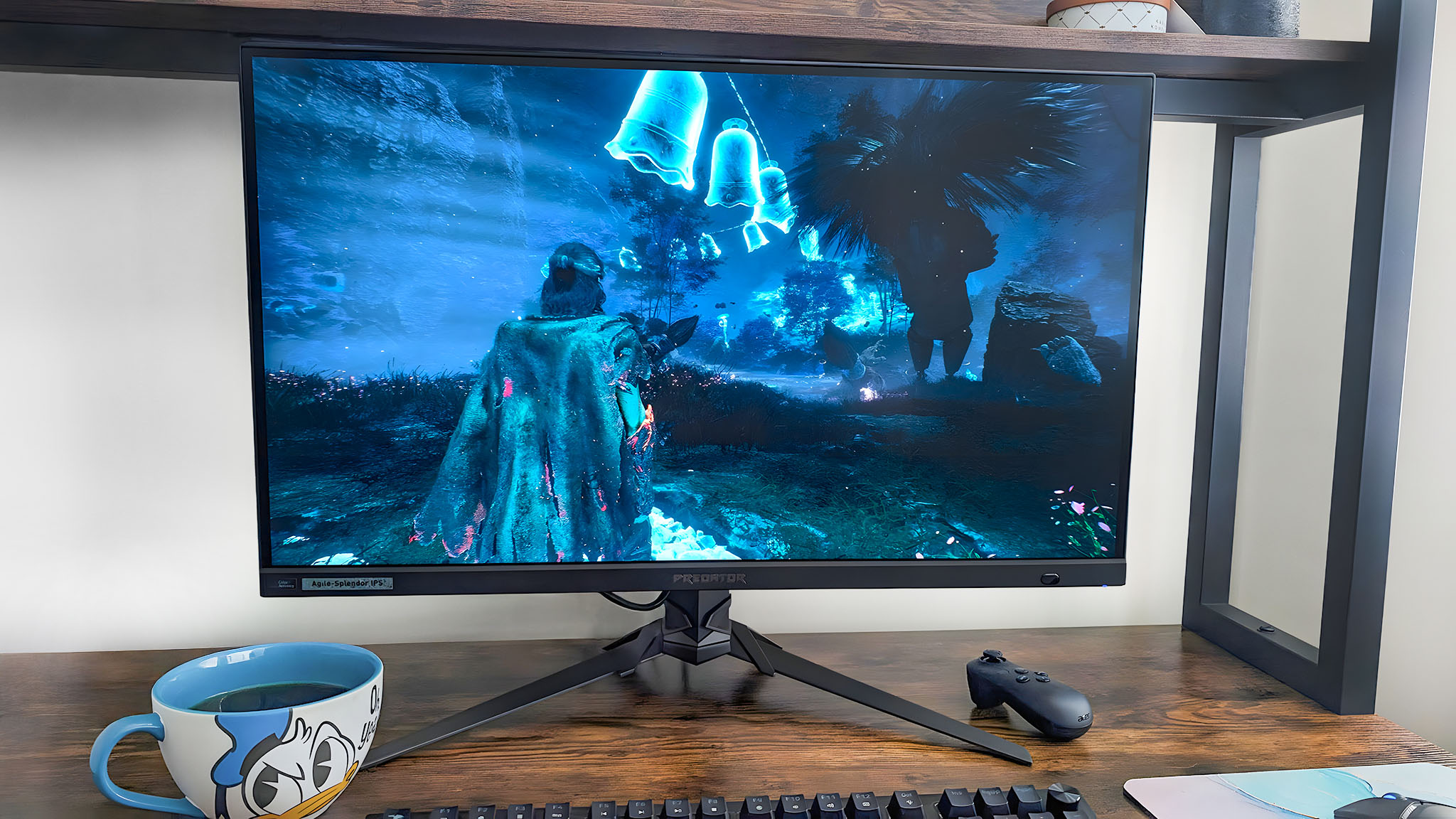 The Acer Predator XB273K monitor on a desk and displaying a scene with Verso and glowing blue bells from Clair Obscur: Expedition 33.