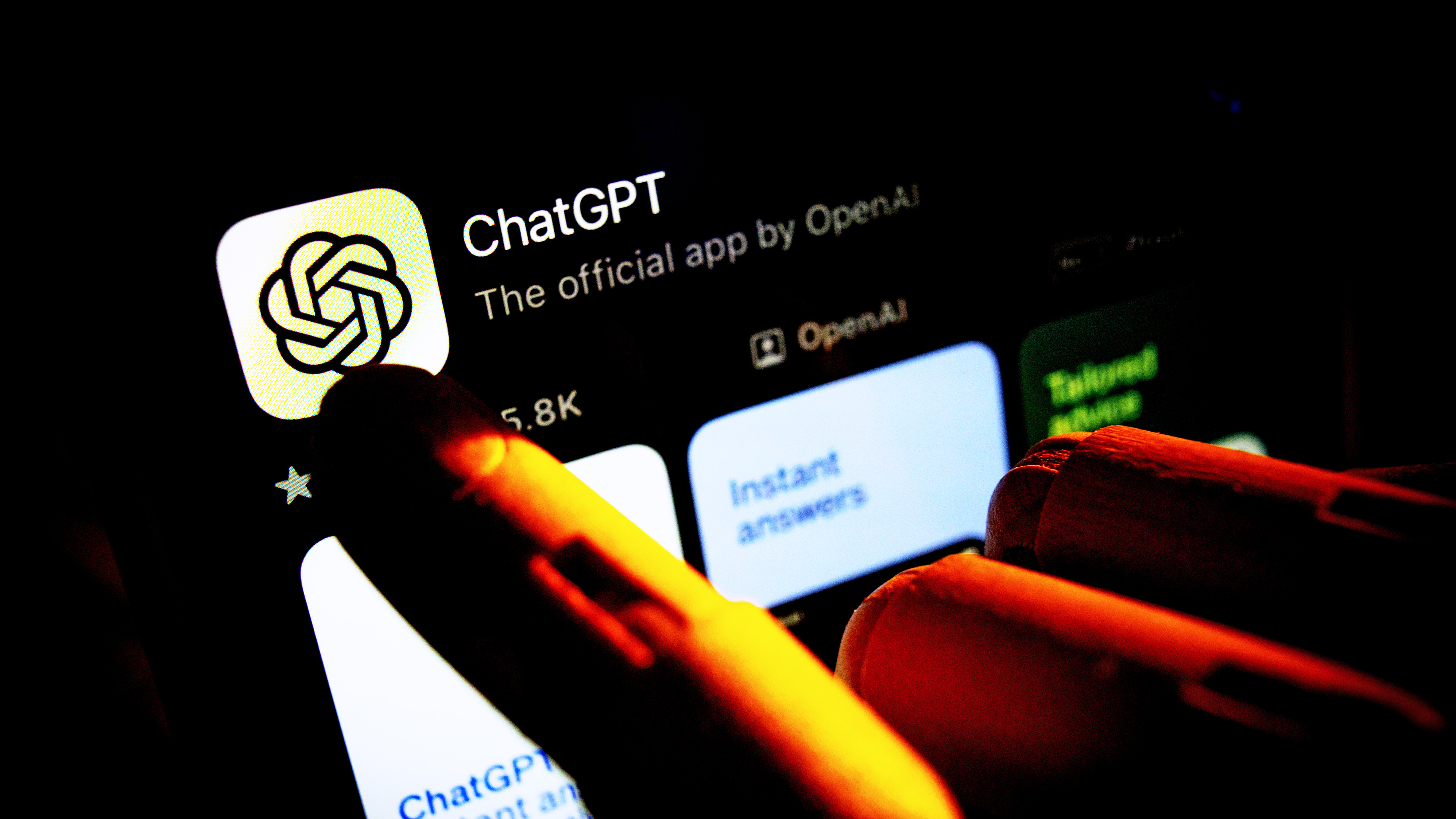 Искусственная рука, указывающая пальцем на экран мобильного телефона, отображающий Apple App Store с приложением Chat GPT на этой фотоиллюстрации 29 октября 2023 года в Варшаве, Польша. (Фото: Jaap Arriens/NurPhoto через Getty Images)