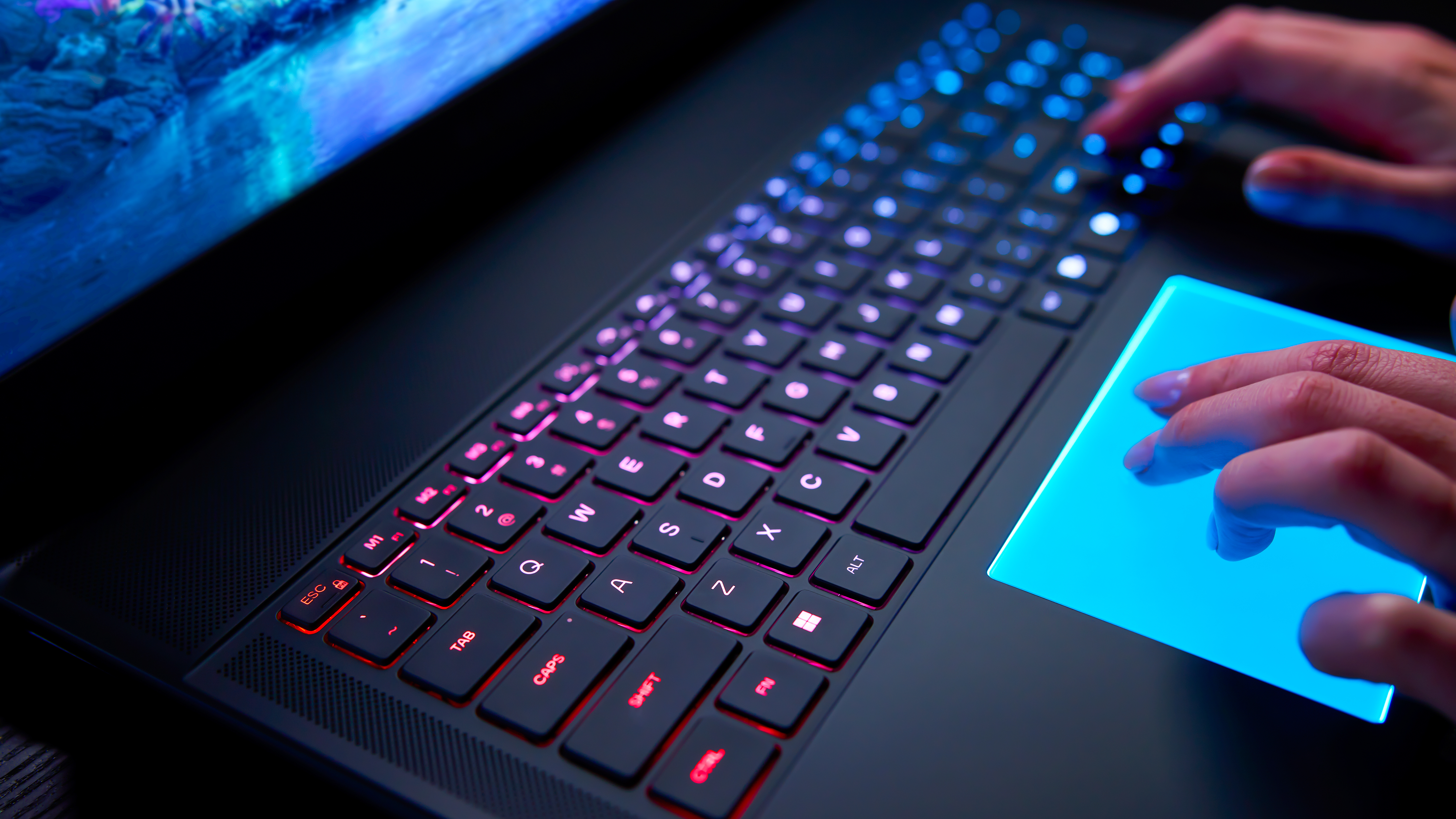 Acloseup of the Alienware Area-51 laptop's backlit mechanical keyboard and RGB touchpad.