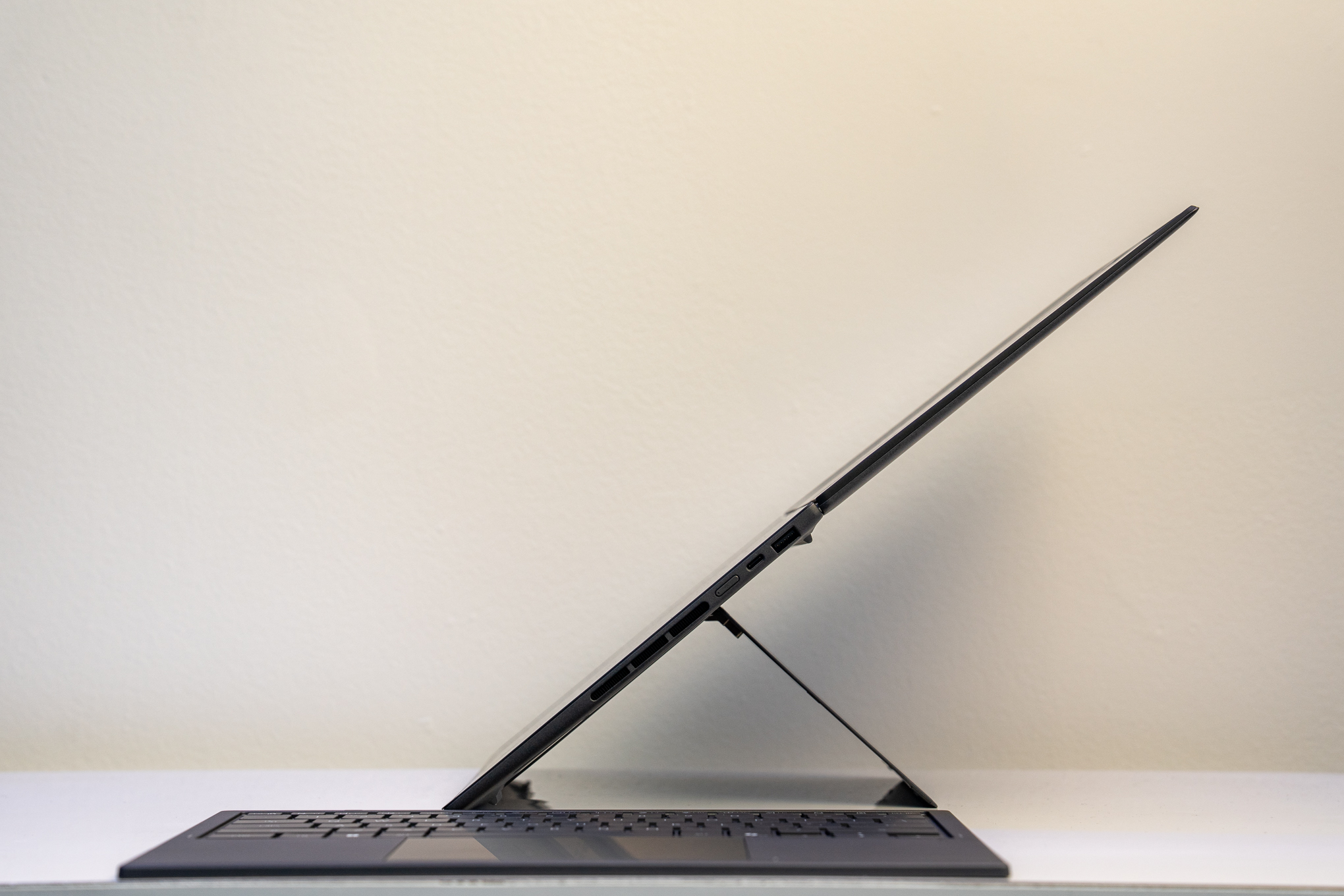 The laptop is shown closed on a stand.