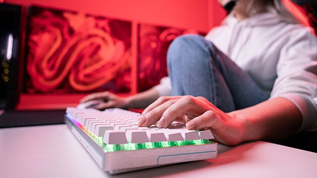 player types on gaming keyboard with multicolored backlighting