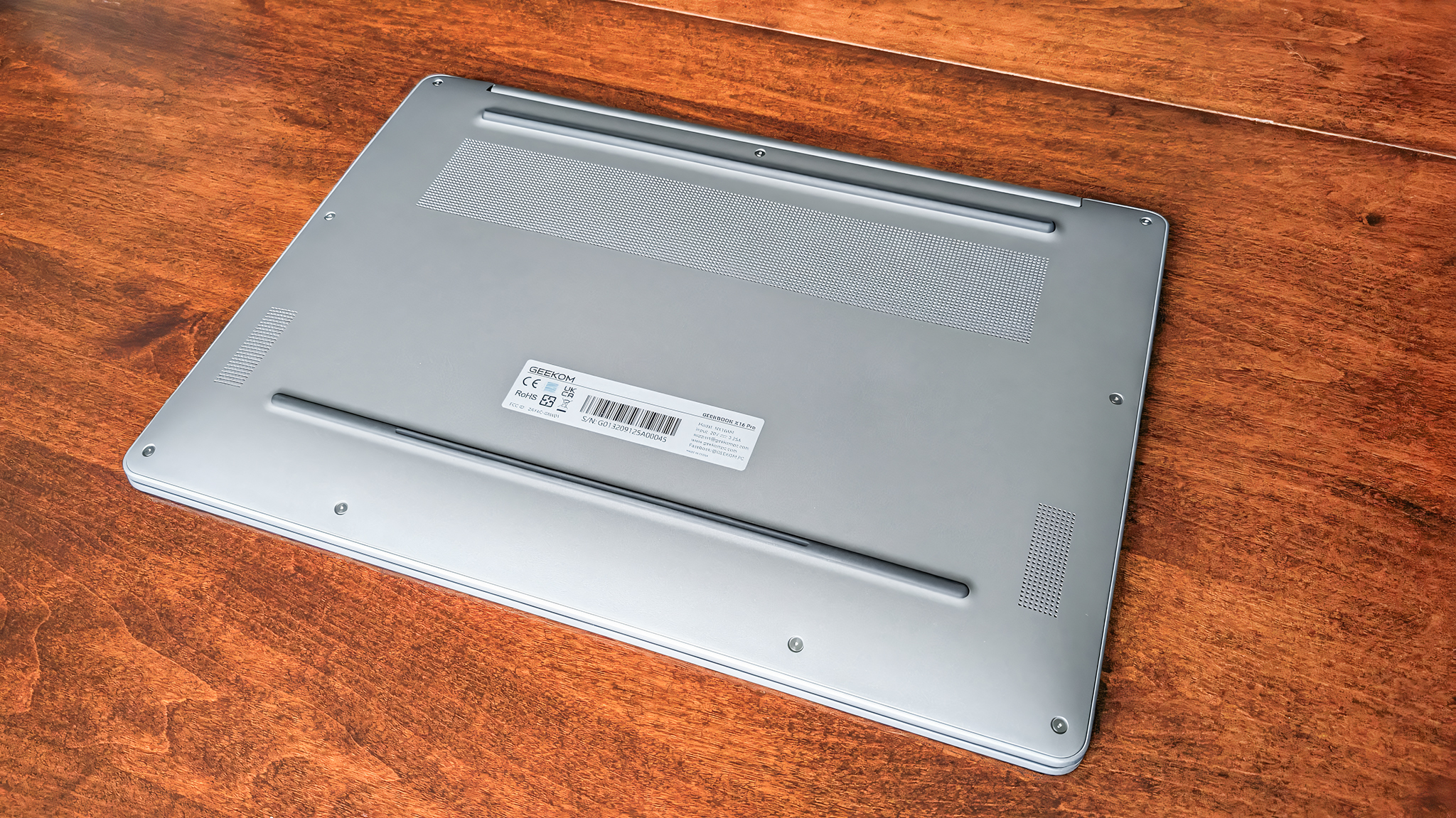 Нижняя часть Geekom GeekBook X16 Pro, стоящего на столе.