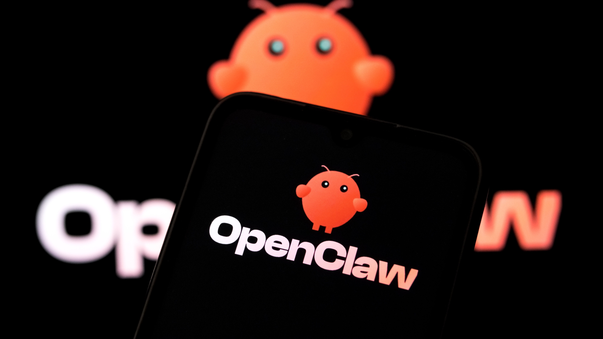 Логотип OpenClaw на экране смартфона и ноутбука.