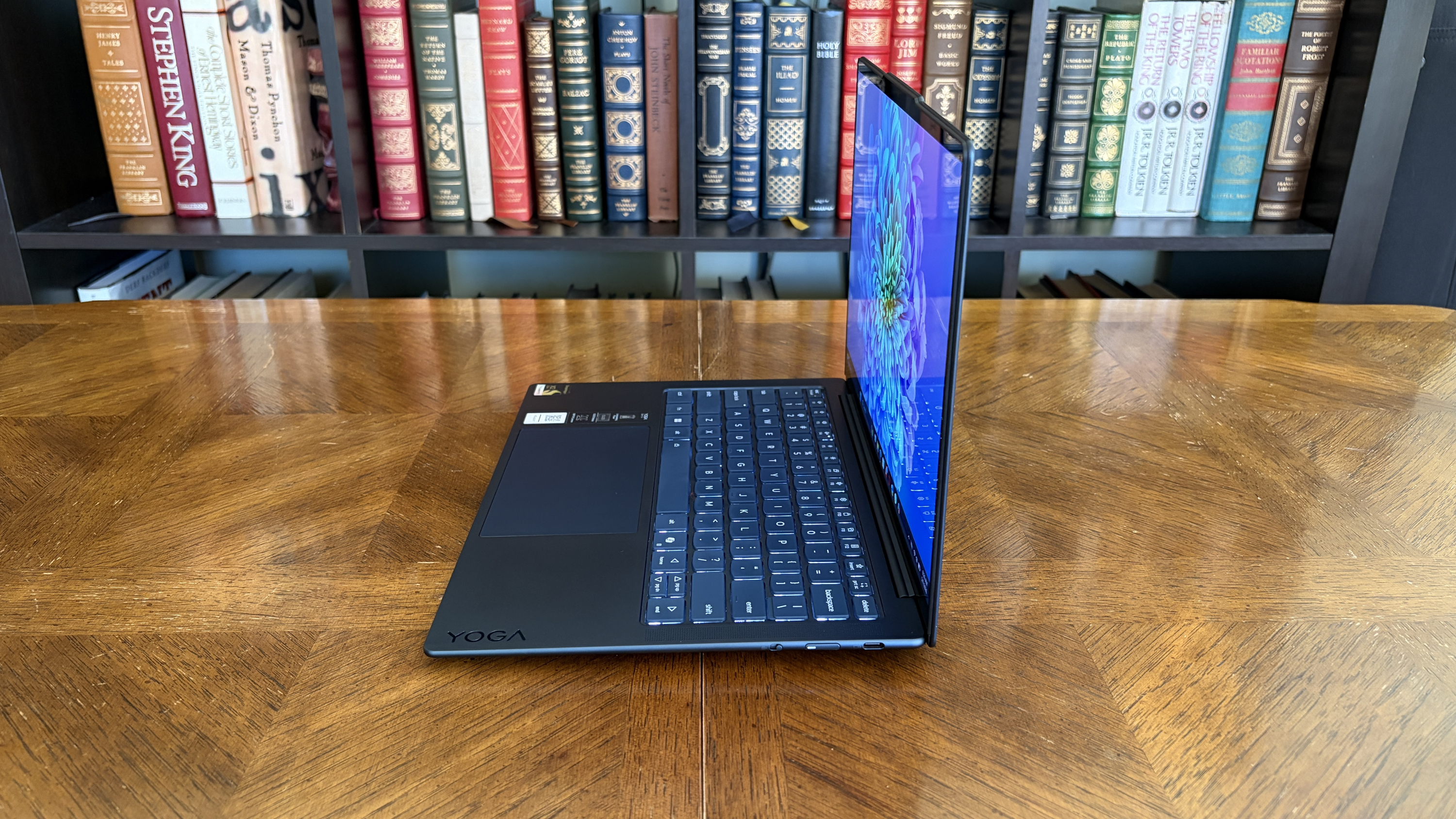 A side view of the Yoga Slim 7x (Gen 11) sitting open on a table.