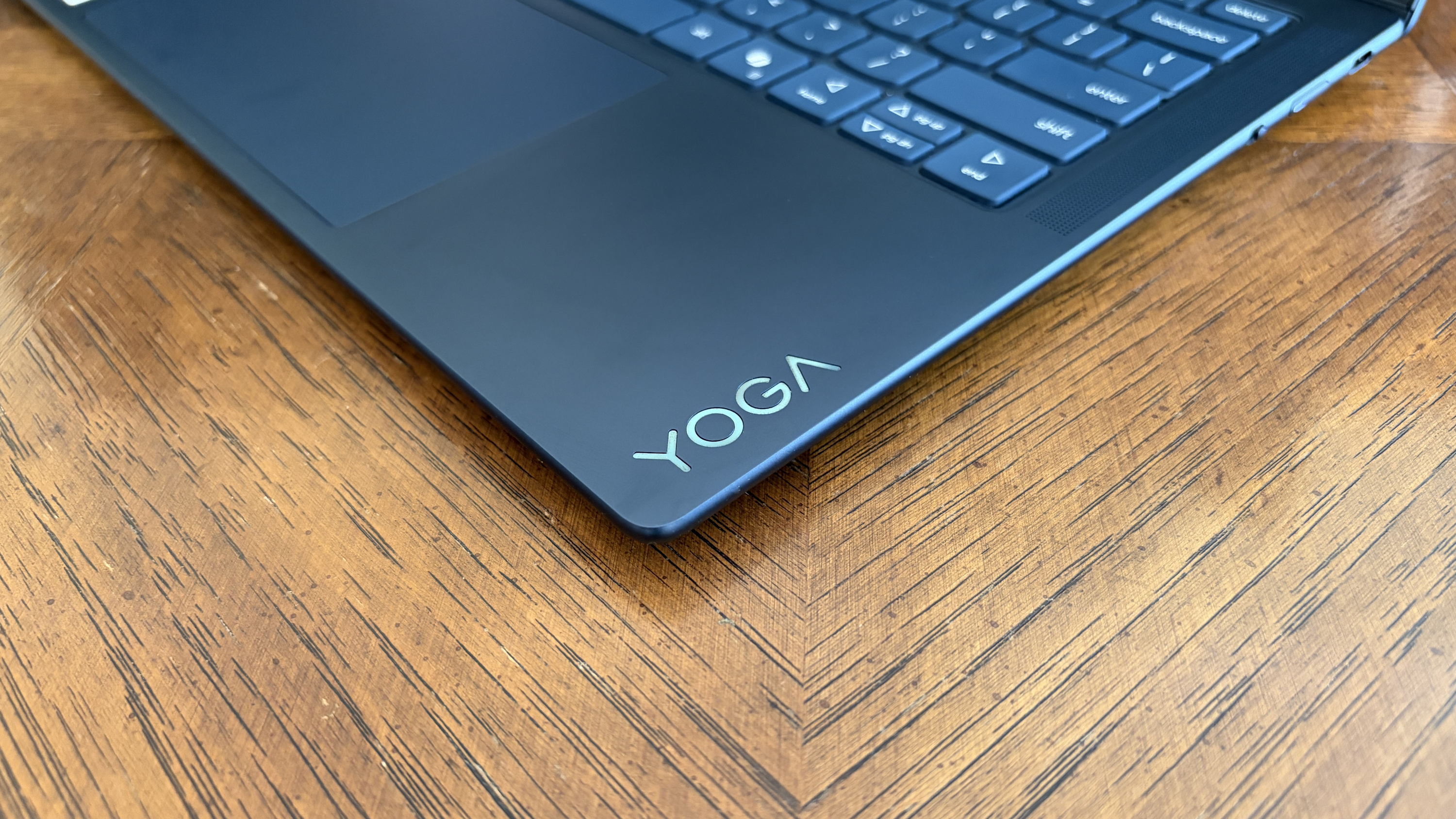 A metallic Yoga logo is embedded in the bottom-right corner of the laptop's palm rest.