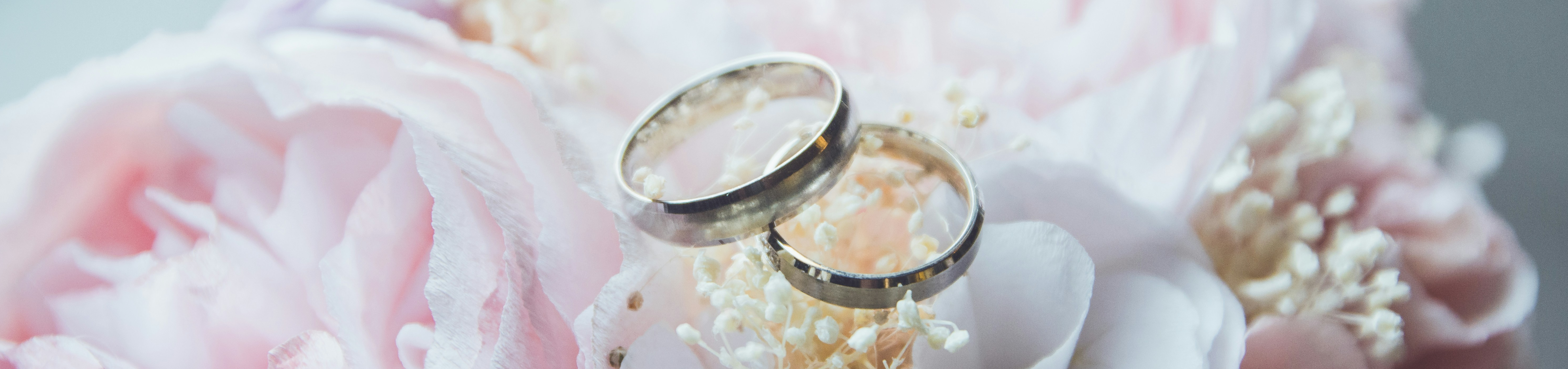Wedding rings on top of pink and white flowers
