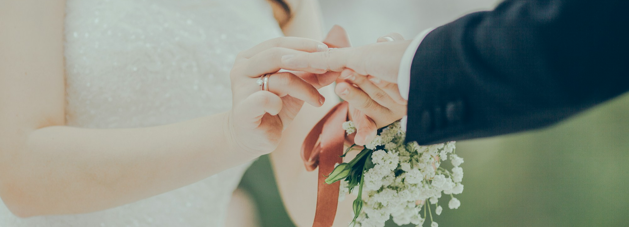 Bride placing ring on grooms finger