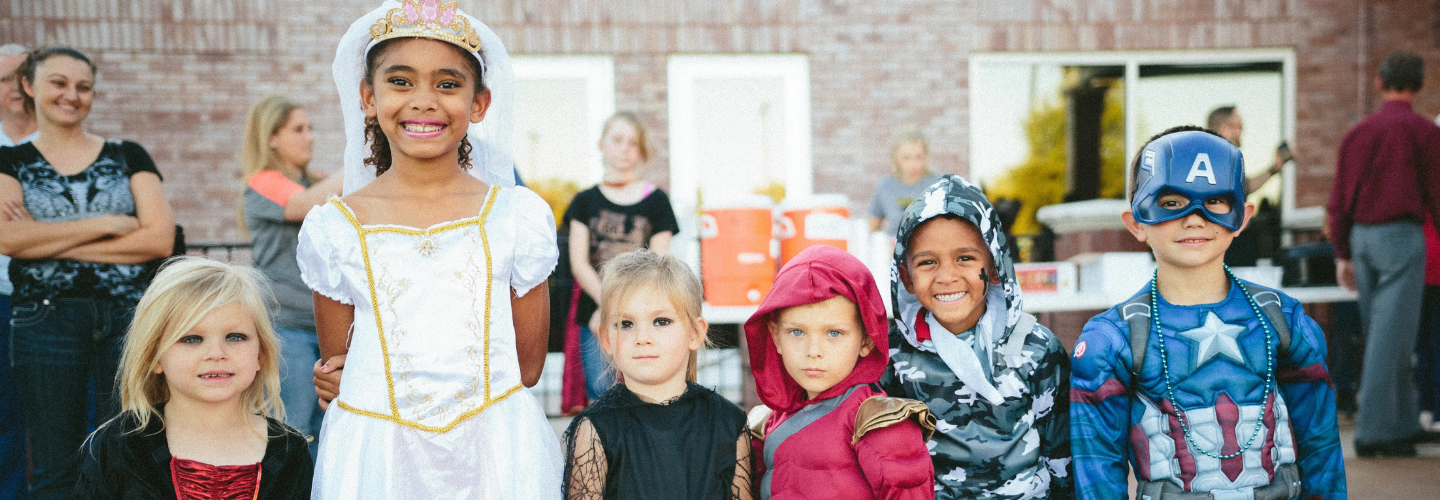 A group of smiling children wearing fancy dress costumes